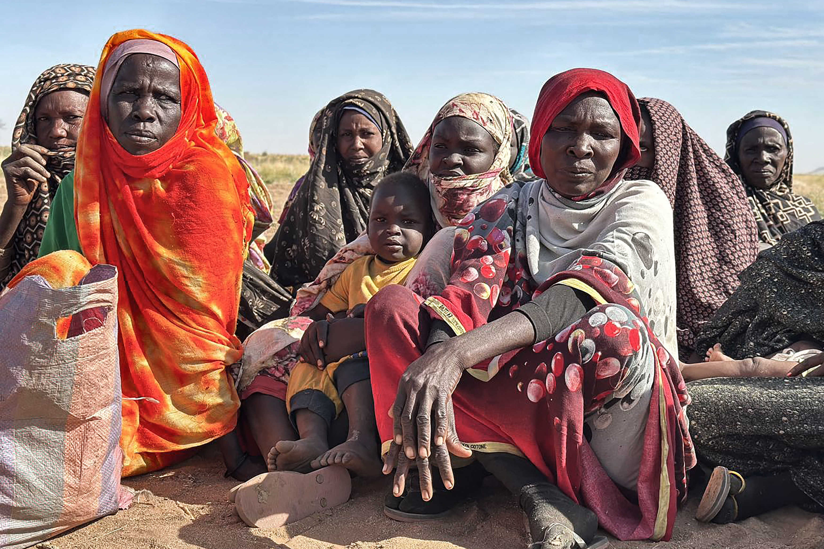 Displaced Sudanese women and children gather at a camp.