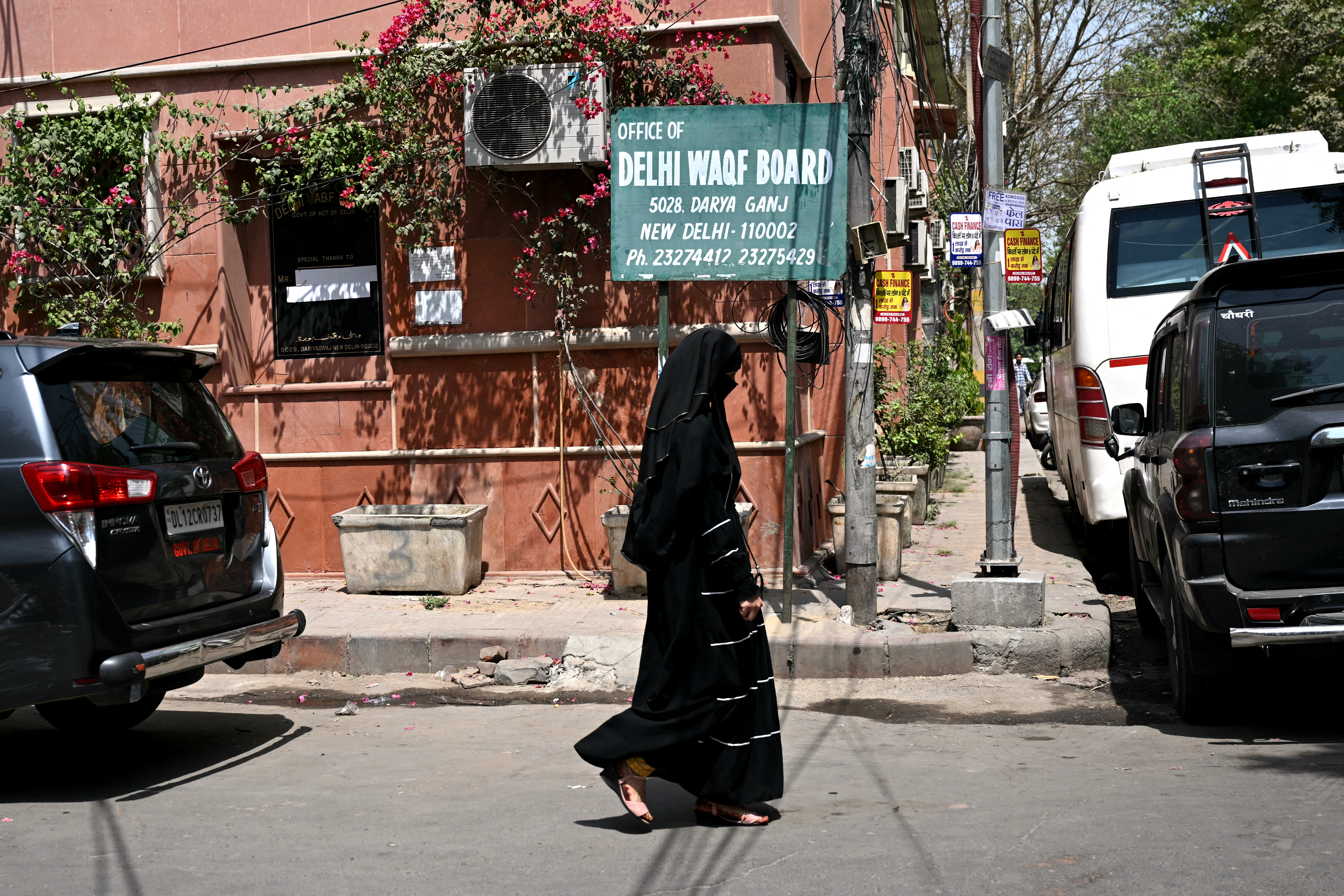 A veiled Muslim woman walks past the Delhi Waqf Board office.
