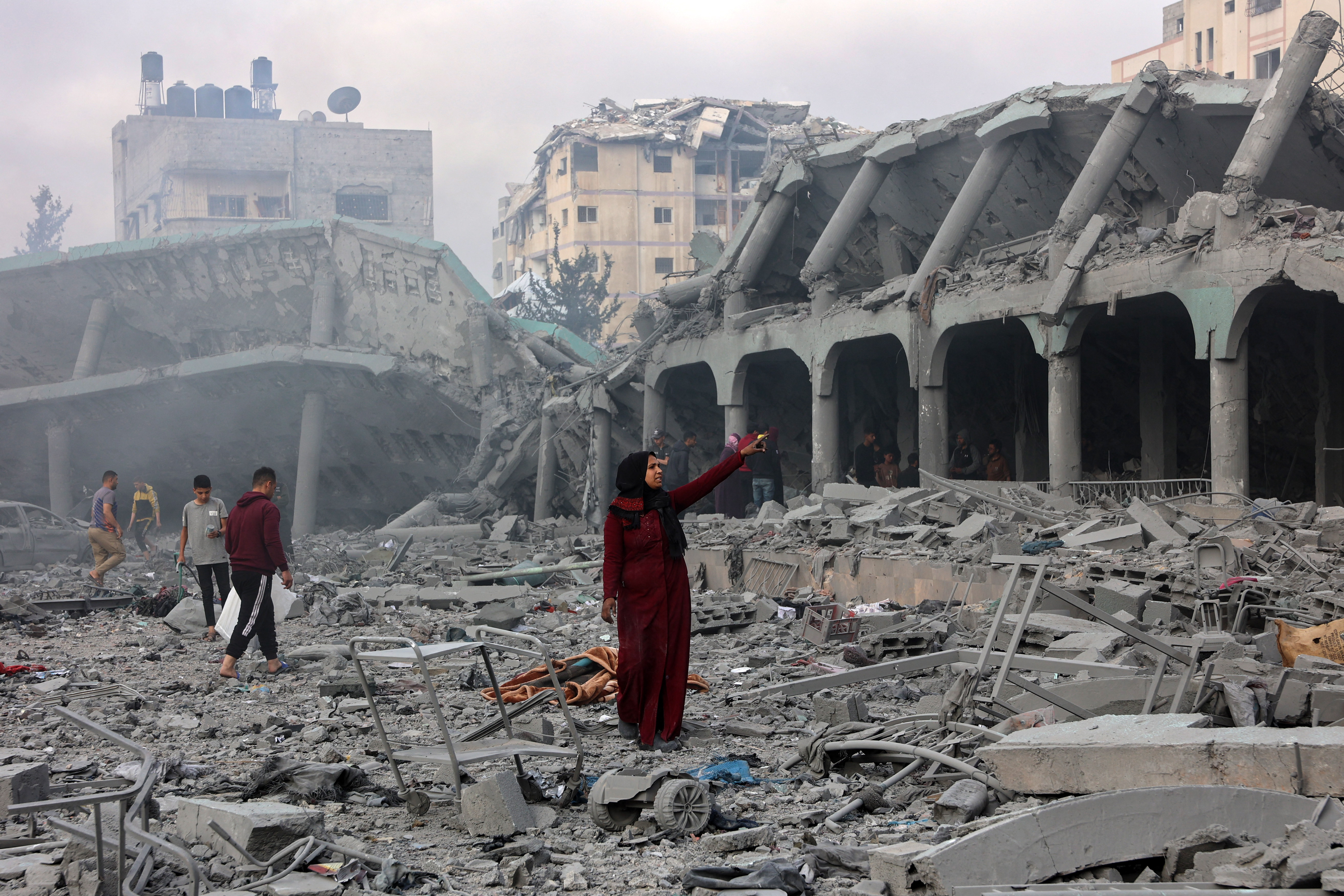A Palestinian woman stands amid the devastation in the yard of a school, a day after it was hit by an Israeli strike, in the al-Tuffah neighbourhood in Gaza City on April 4, 2025. Gaza's civil defence agency said on April 3 that at least 31 people, including children, were killed in the Israeli strike on the school serving as a shelter for Palestinians displaced by the war. (Photo by Omar AL-QATTAA / AFP)