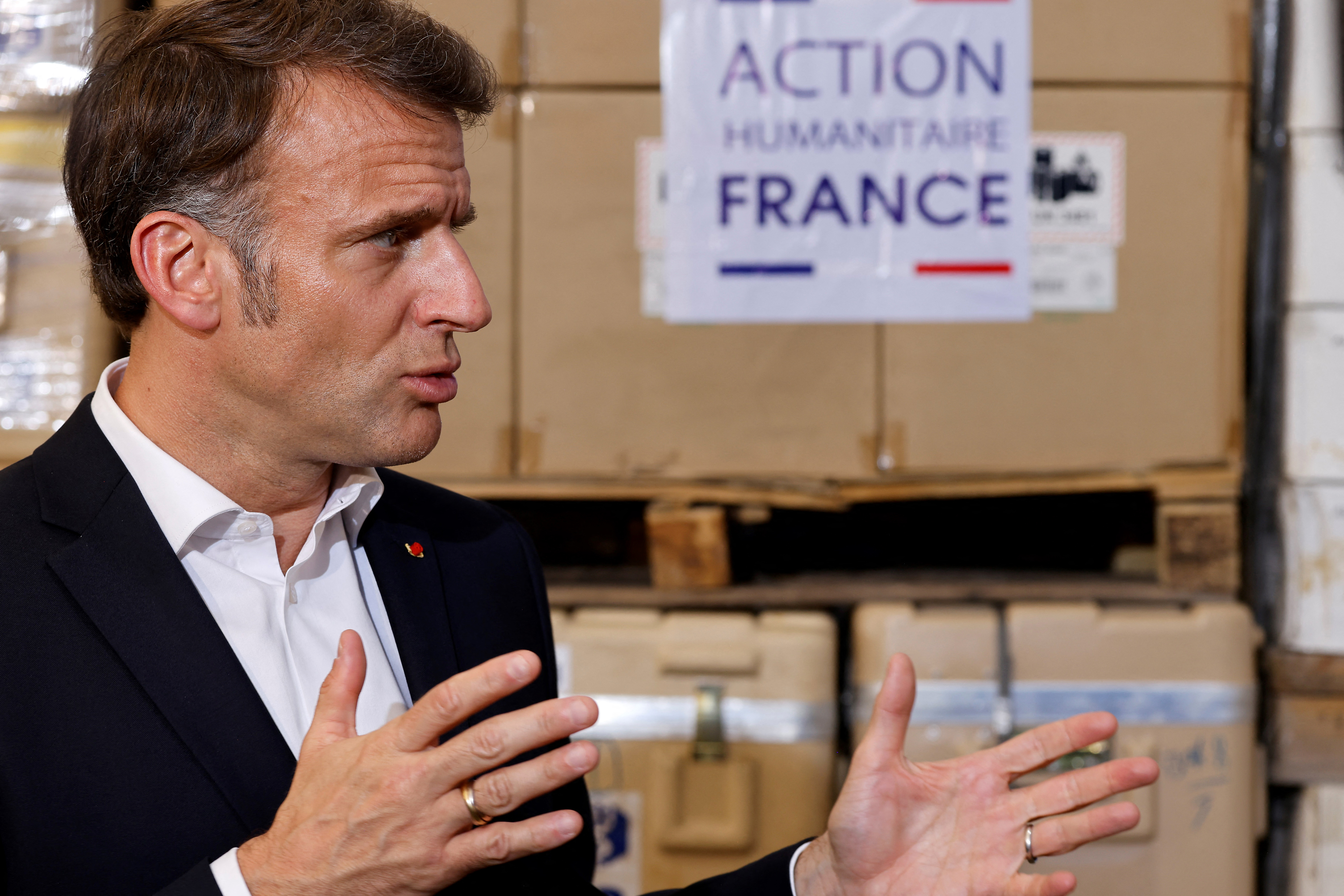France's President Emmanuel Macron delivers a speech in front of humanitarian aid destined for Gaza