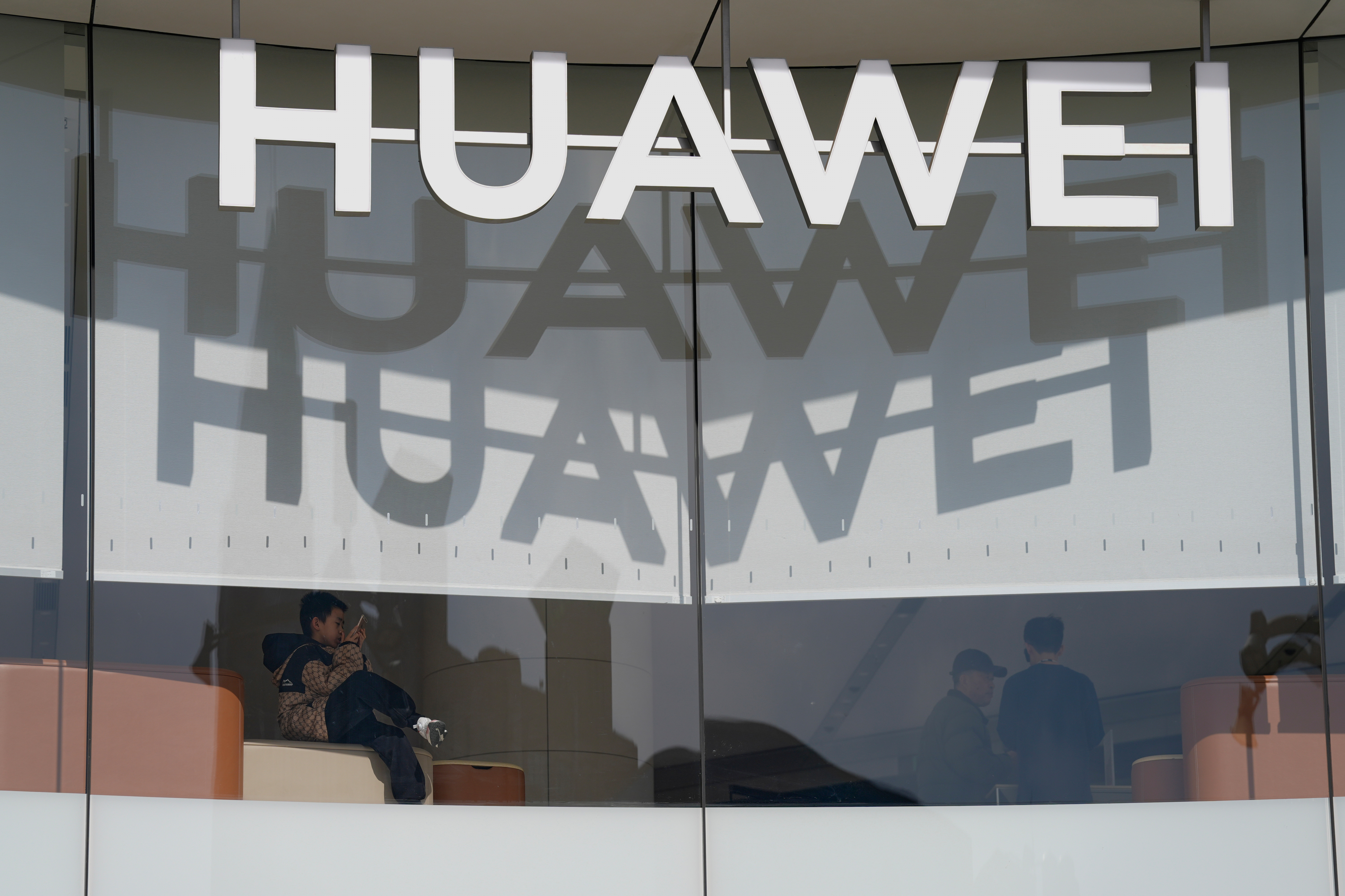 A child rests in a flagship store for Chinese telecoms equipment giant Huawei along the Wangfujing shopping street in Beijing, China, on March 6, 2025.
