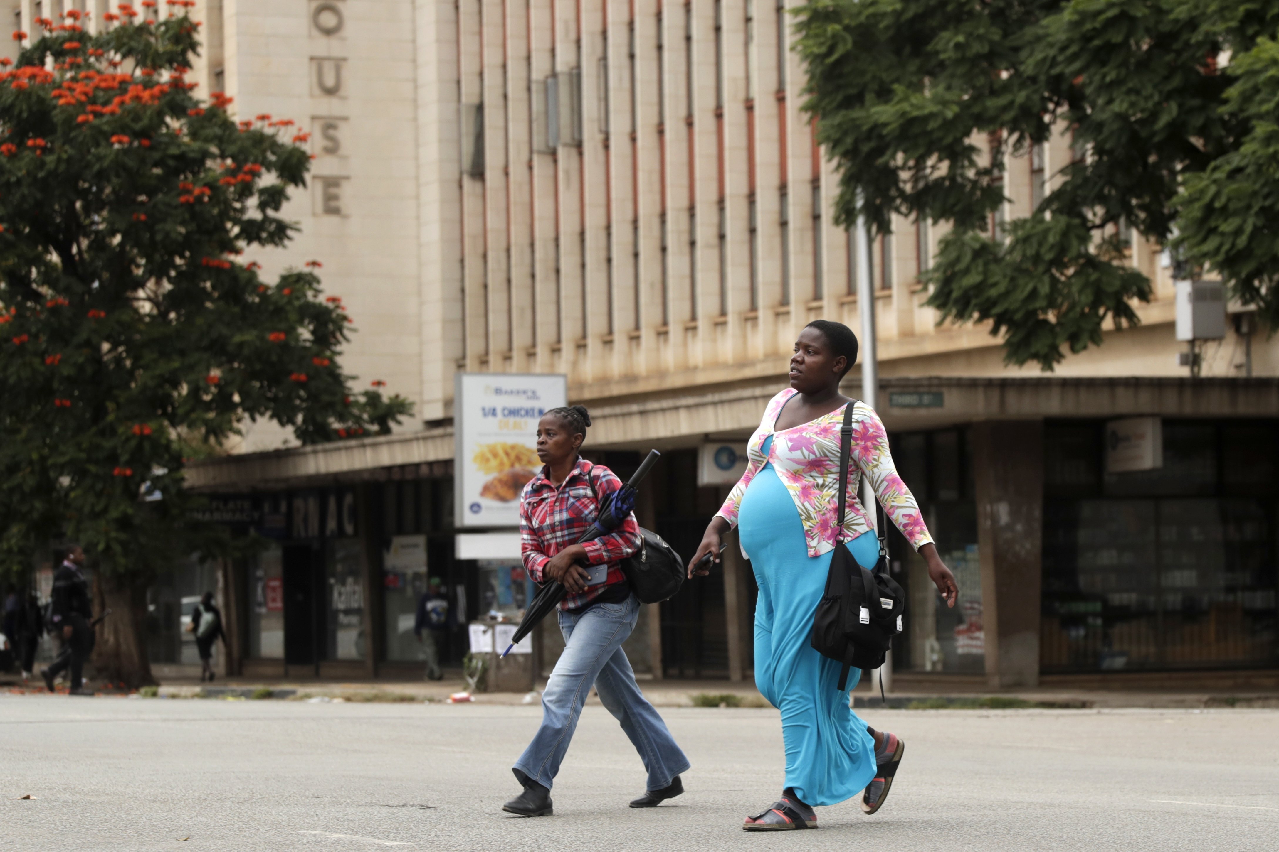 Women walk across a deserted street in downtown Harare, Zimbabwe, on March 31, 2025, following calls for an antigovernment protest [Aaron Ufumeli/AP Photo]