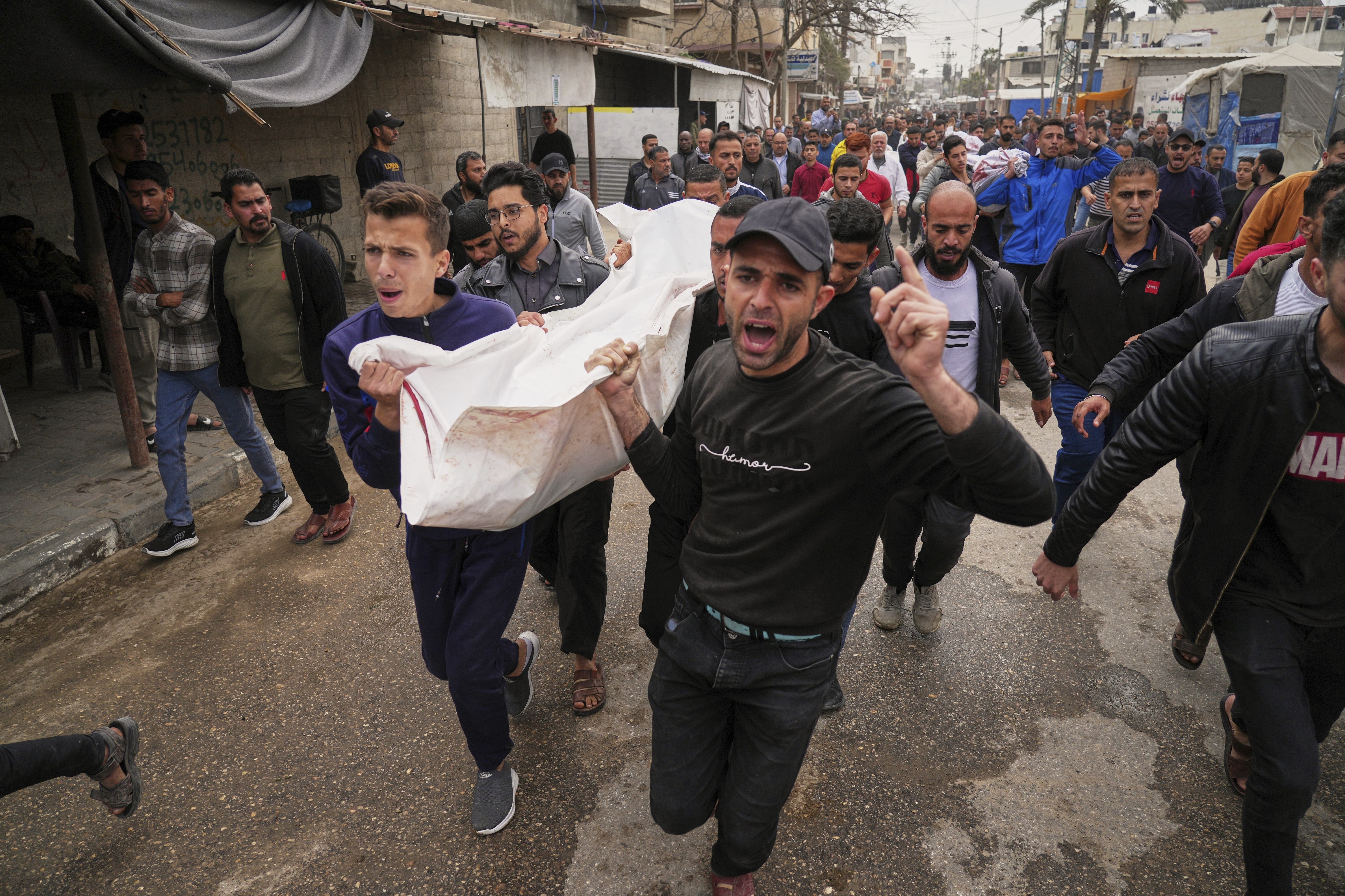 Palestinians carry for burial the bodies of Abdullah Habbash and six brothers from the Abu Mahadi family, members of a Palestinian charity organization linked to Hamas, who were killed earlier in an Israeli army strike on the car they were traveling in, in Deir al-Balah, central Gaza Strip, Sunday, April 13, 2025. (AP Photo/Abdel Kareem Hana)