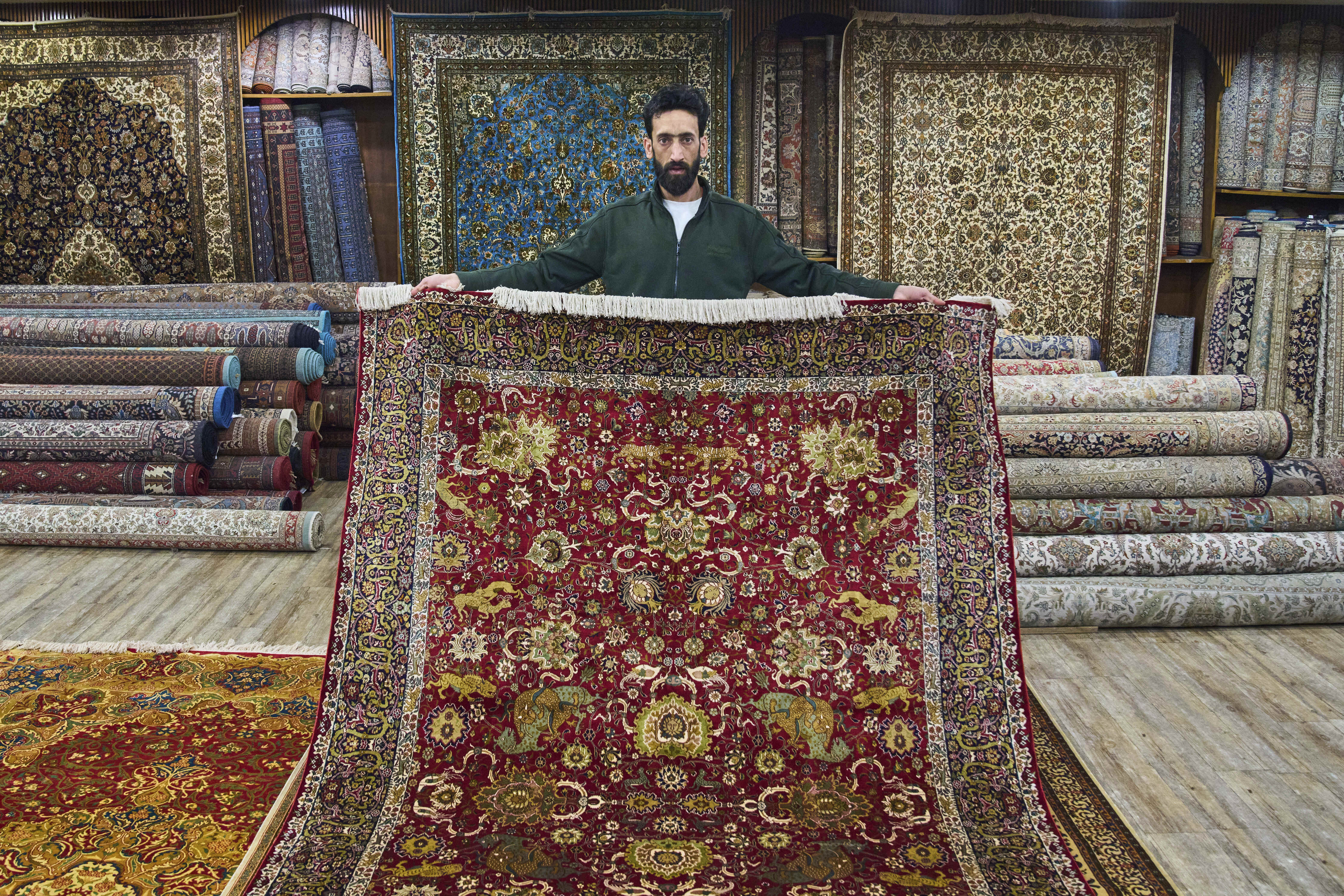 Mohammad Iqbal Bakshi displays a Kashmiri hand-knotted silk carpet.