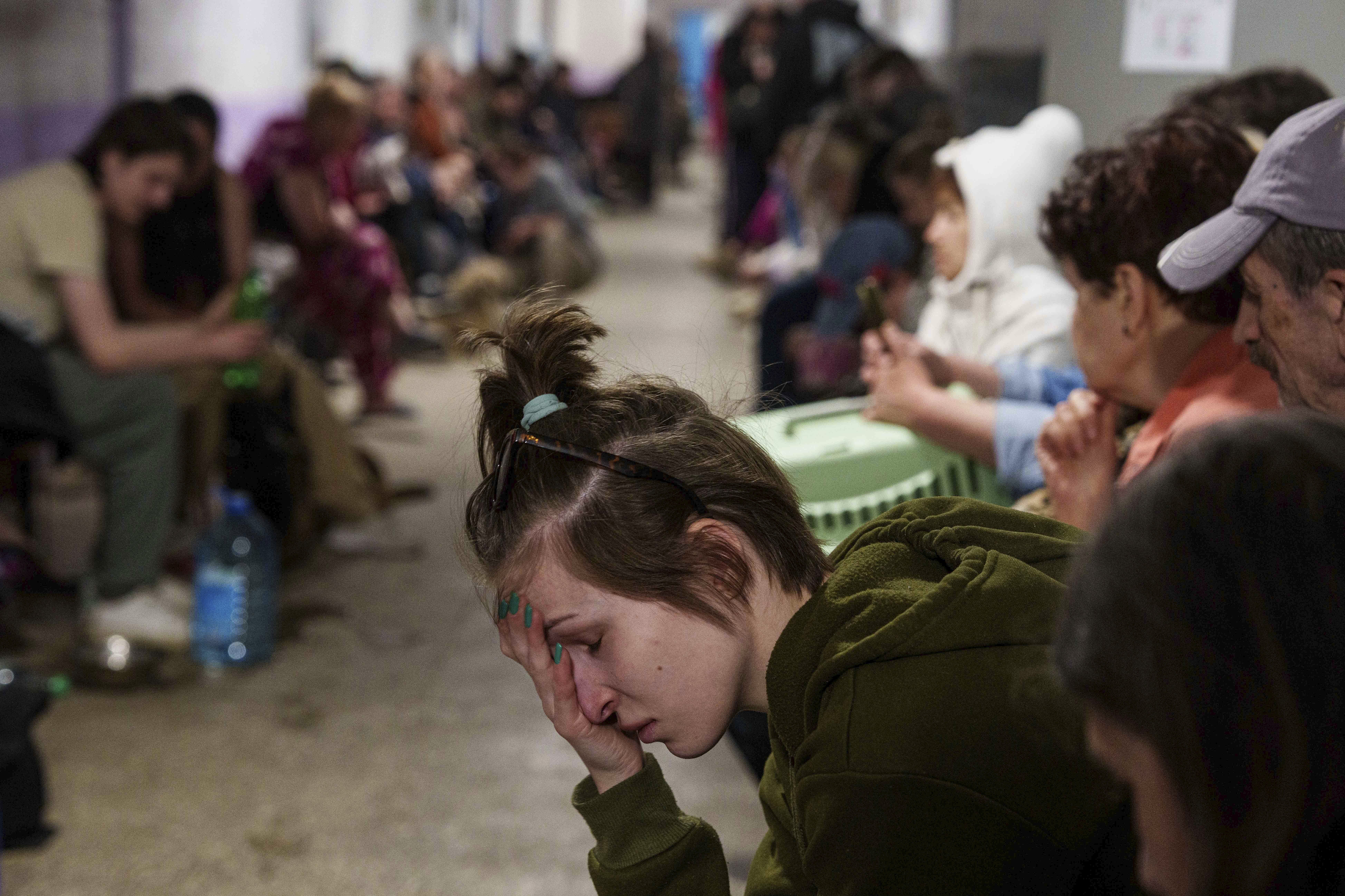A woman sits in a school basement being used as a shelter.