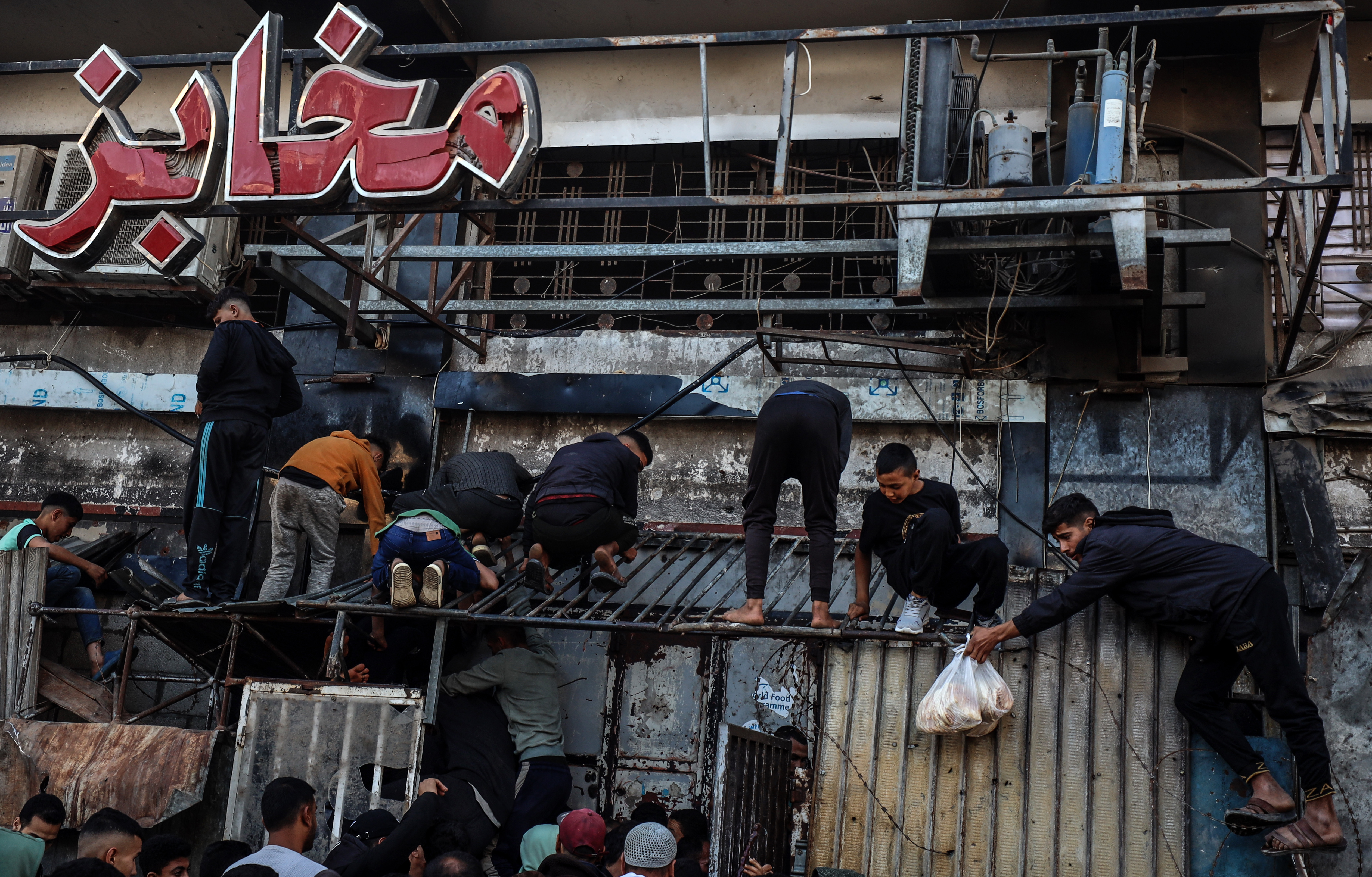 Palestinians wait for bread outside a bakery