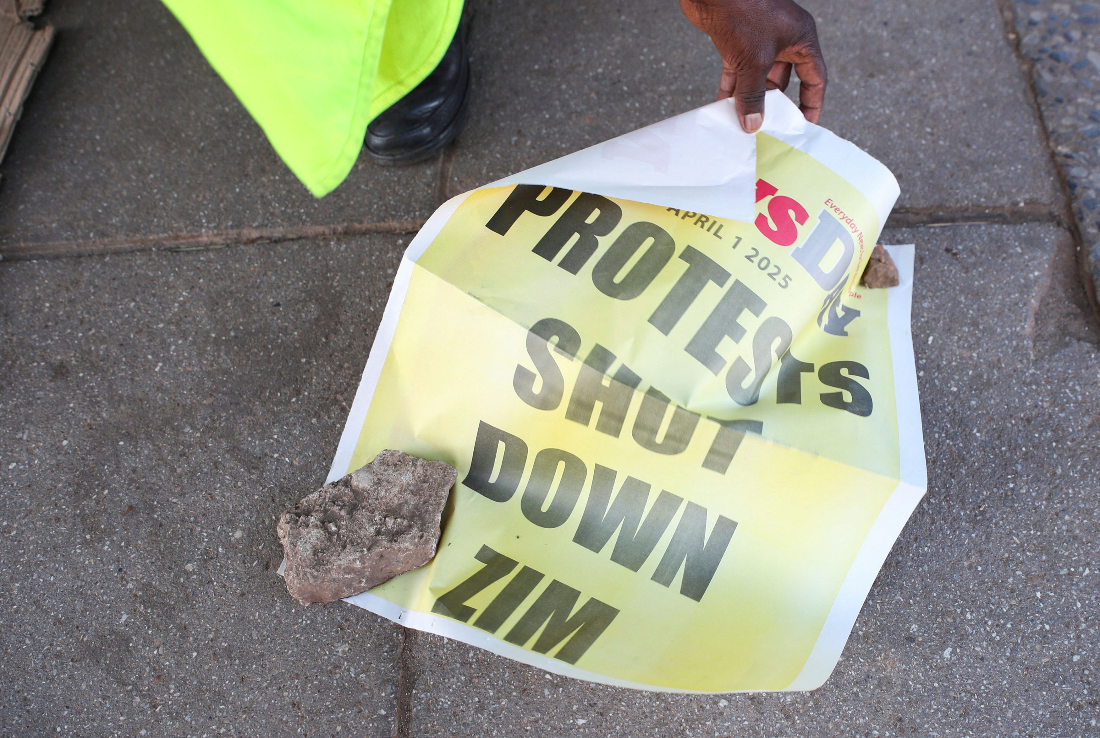 A newspaper vendor shows a standee in the capital Harare