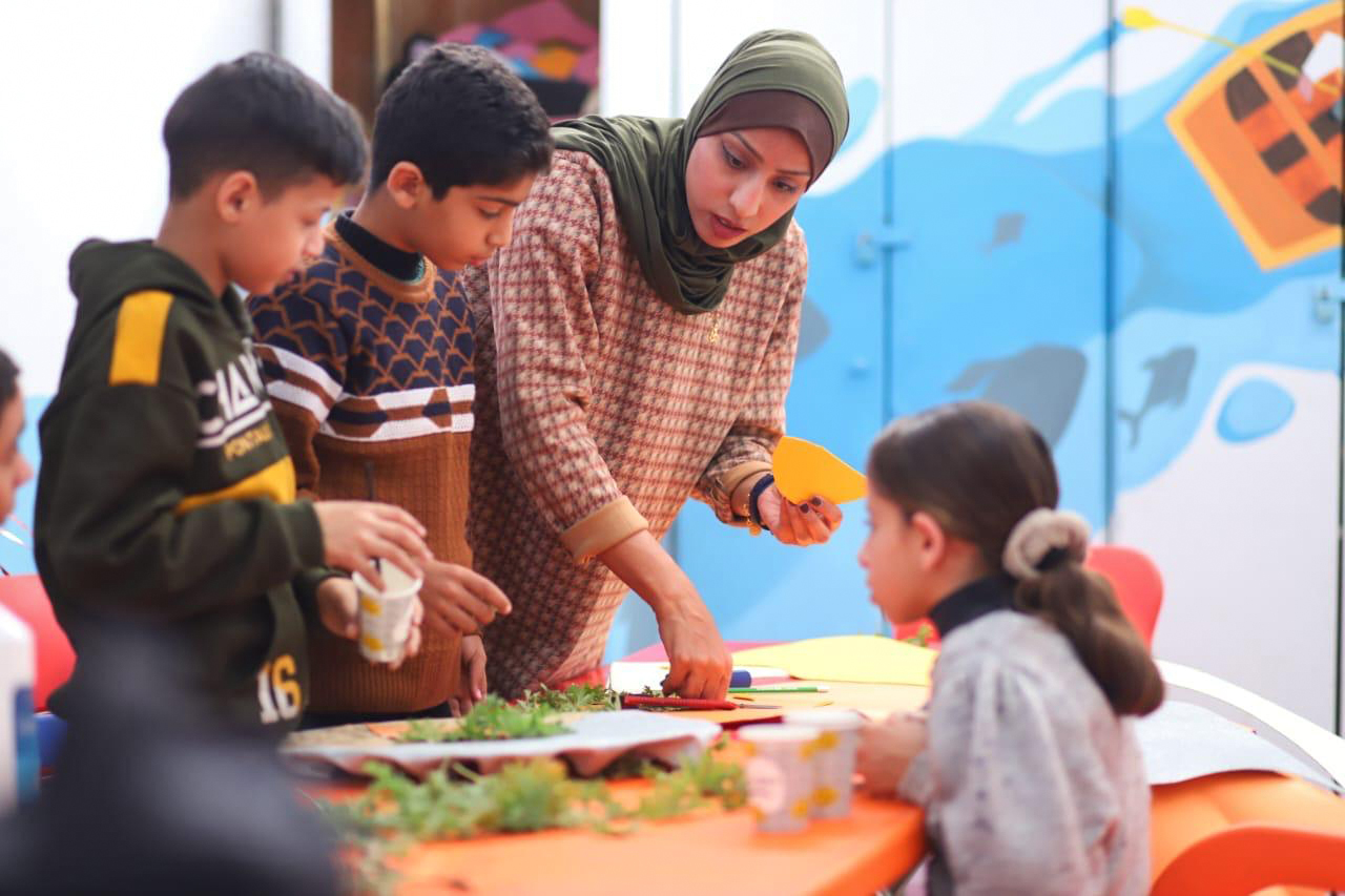 Ruwaida with her students in a bright classroom