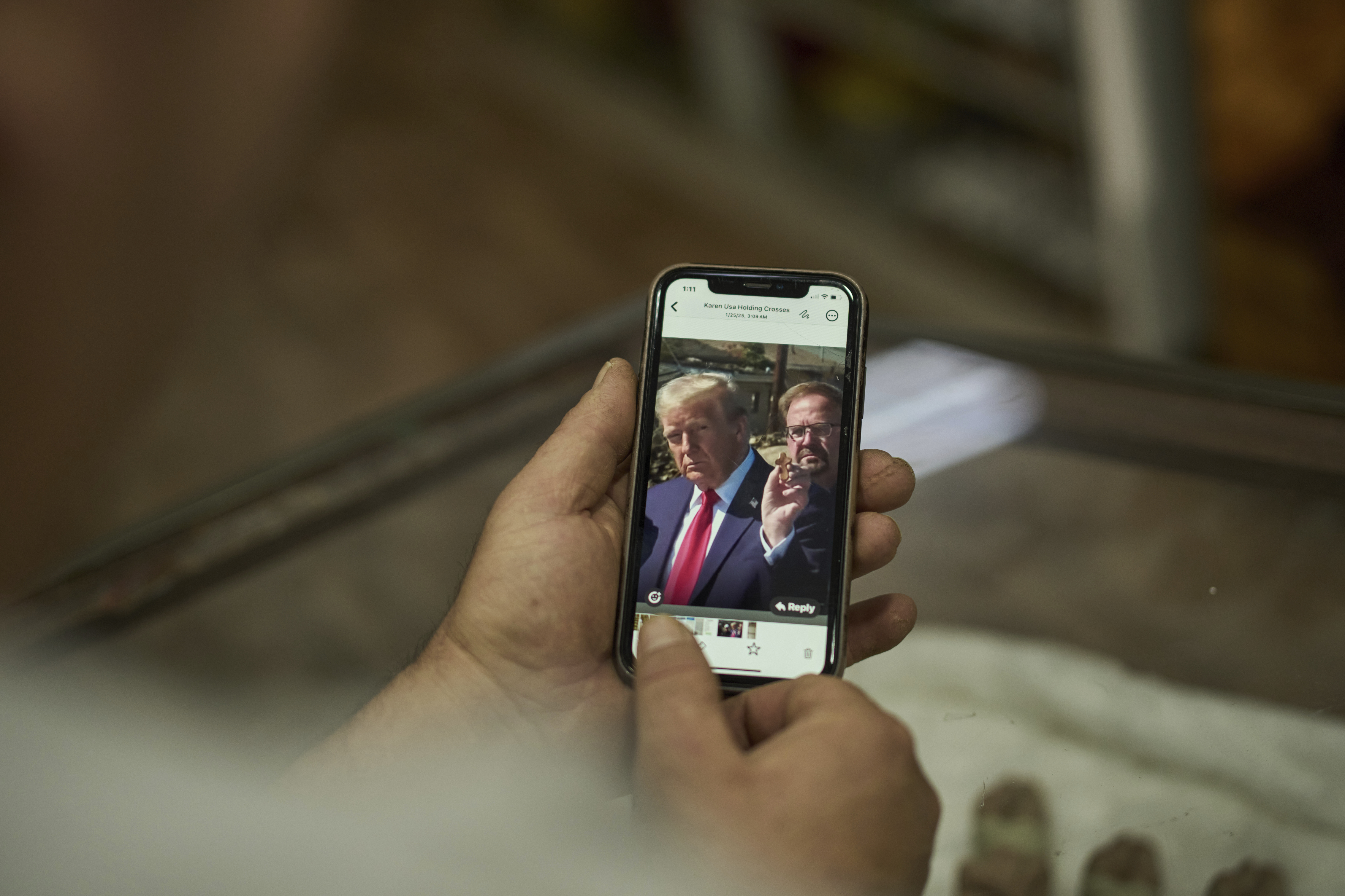 Bassem Giacaman shows a photo on his phone that he received from an American client, of US president Donald Trump holding a small cross that was fabricated in his workshop, as he stands in his gift shop in the West Bank city of Bethlehem, Wednesday, April 9, 2025. (AP Photo/Leo Correa)