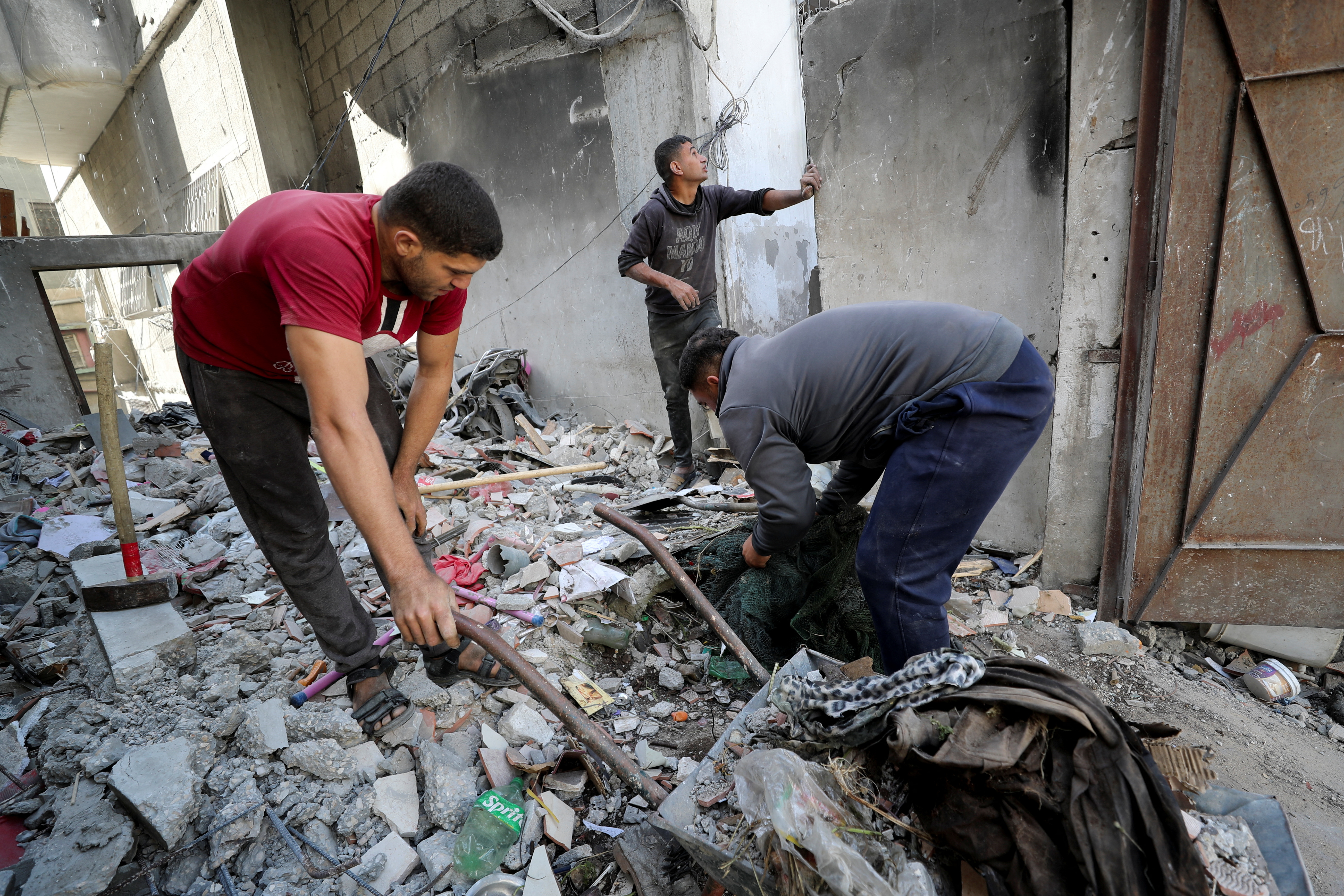 Palestinian men remove debris at the site of an Israeli strike on a house, in Jabalia, in the northern Gaza Strip April 16, 2025. [Mahmoud Issa/Reuters]
