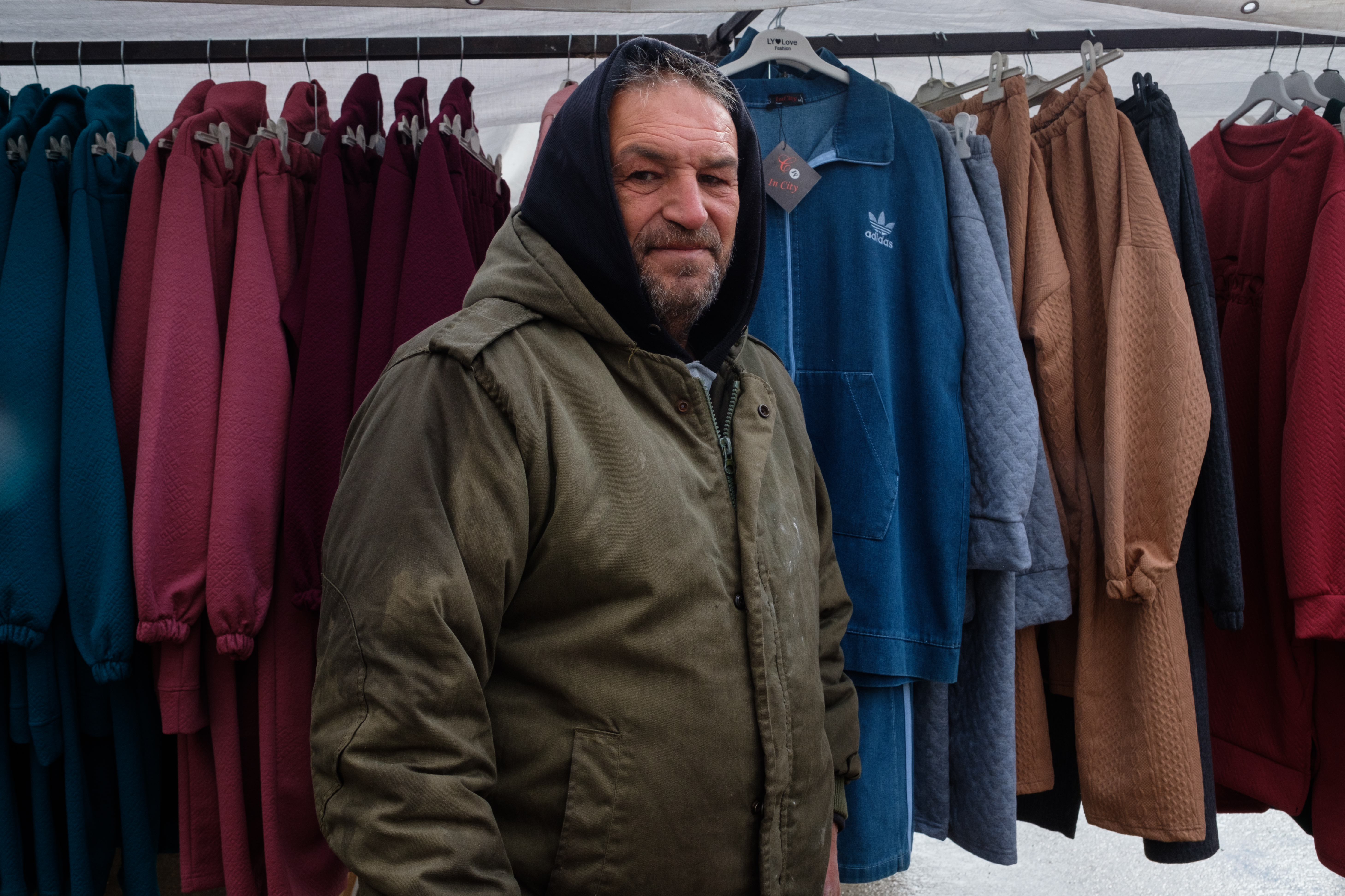 Jihad Abdallah, a middle-aged man with a goatee, has his hoodie up as he's feeling the cold still despite the sun rising