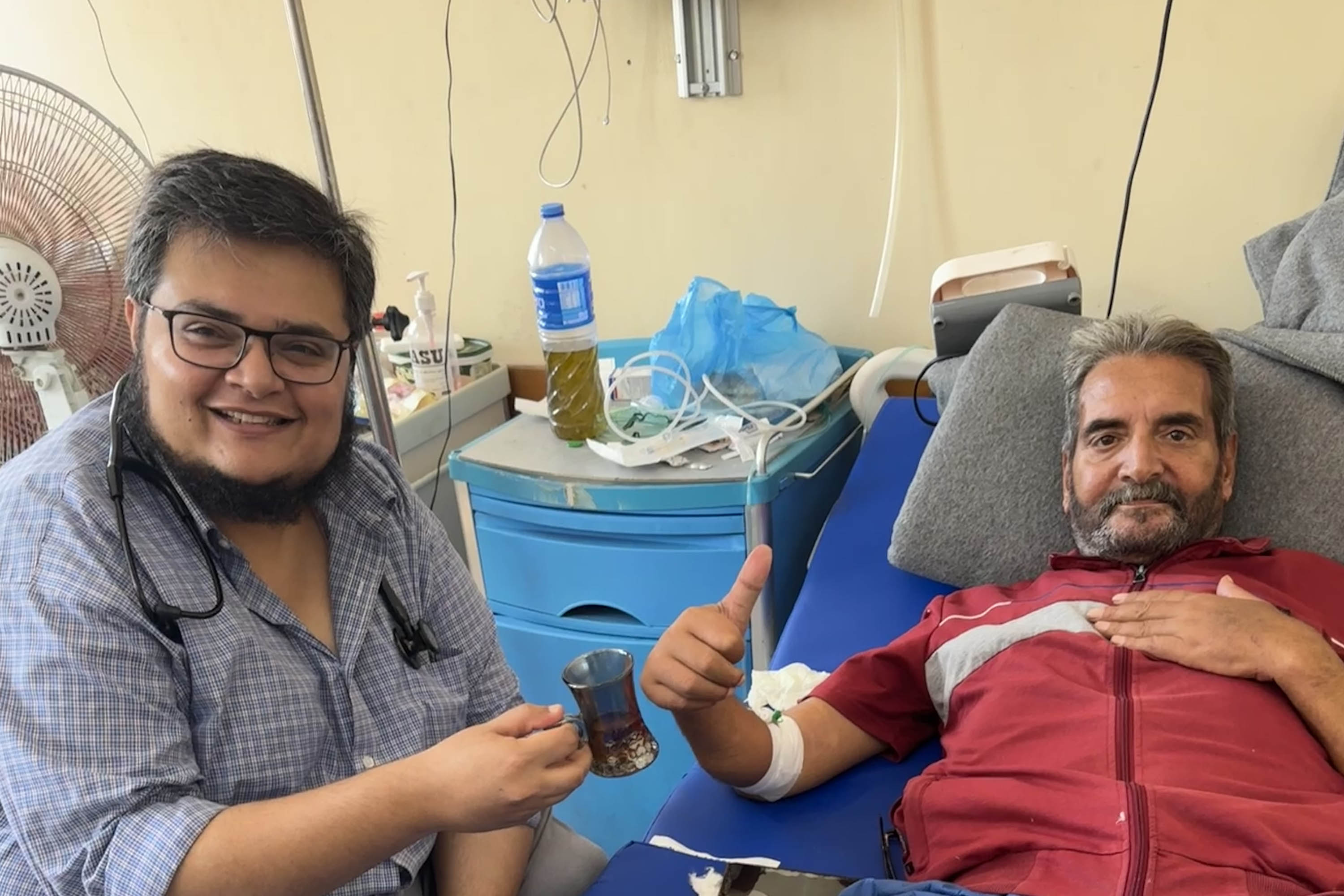 A photo of a doctor and a patient lying on a bed