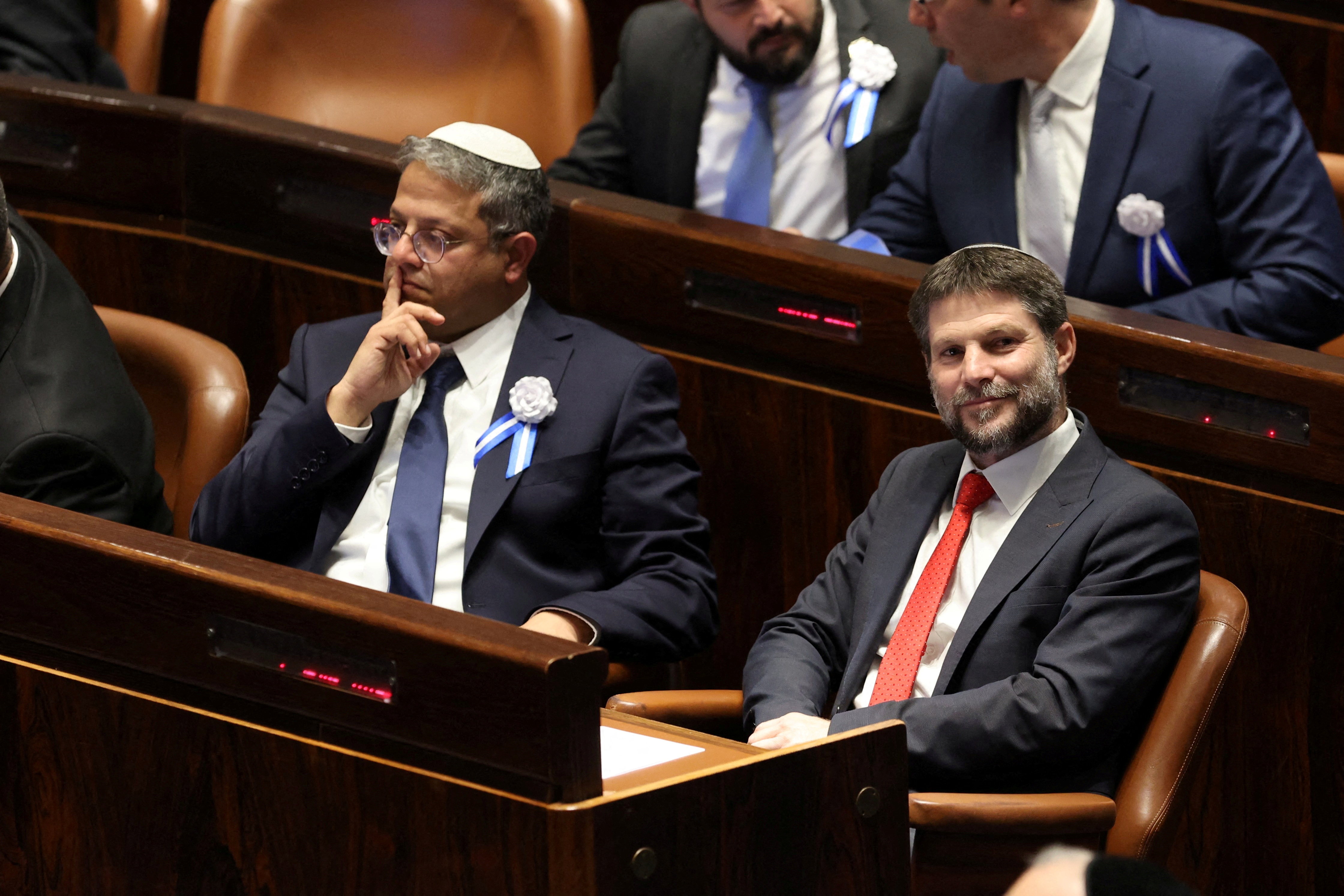 two men in suits sit in a parliamentary chamber