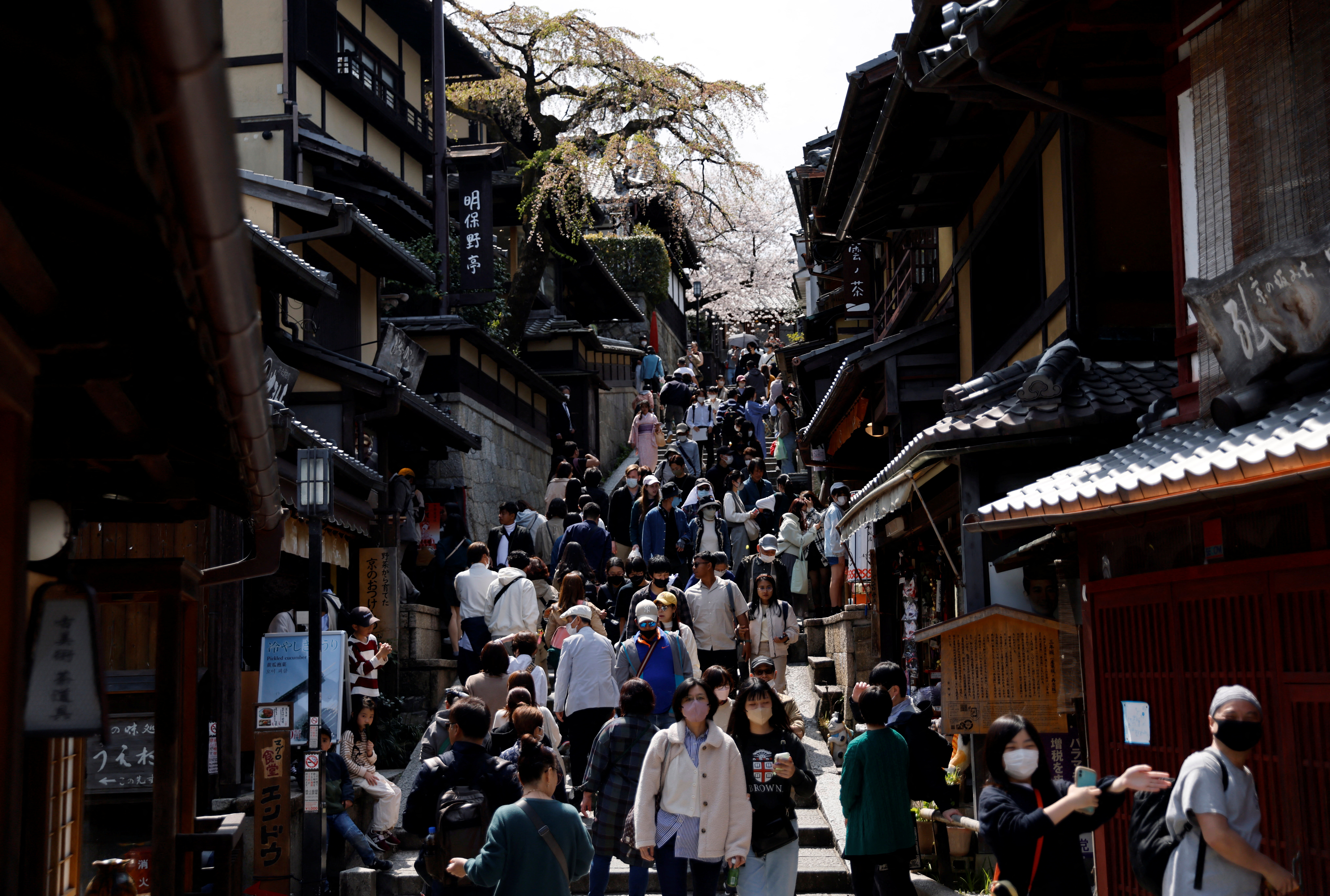 A crowd of tourists walk on the street.