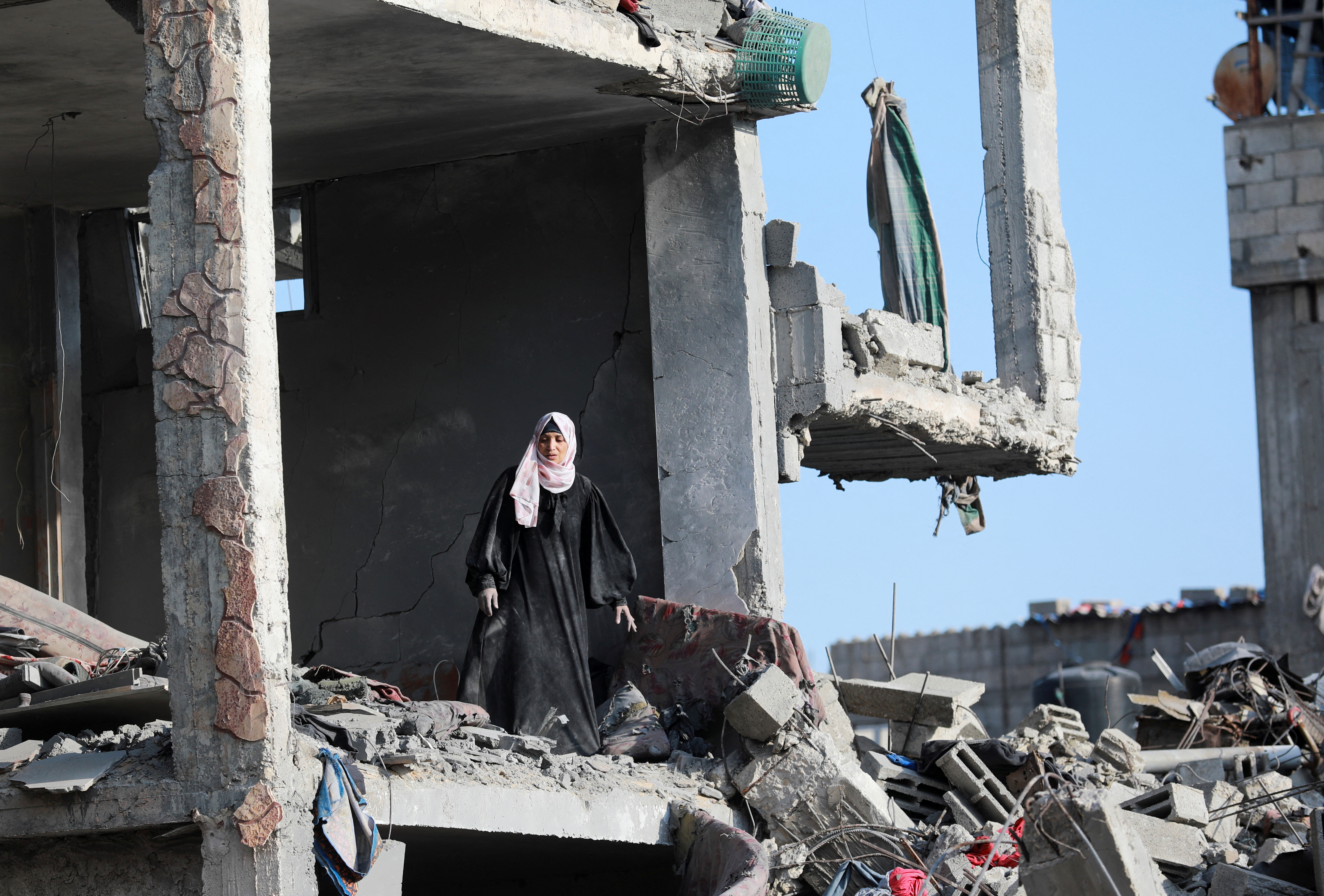 A Palestinian woman stands inside a destroyed building after Israeli forces withdrew from a part of Nuseirat, following a ground operation amid the ongoing conflict between Israel and Hamas, in Nuseirat, central Gaza Strip, November 29, 2024. REUTERS/Abd Elhkeem Khaled