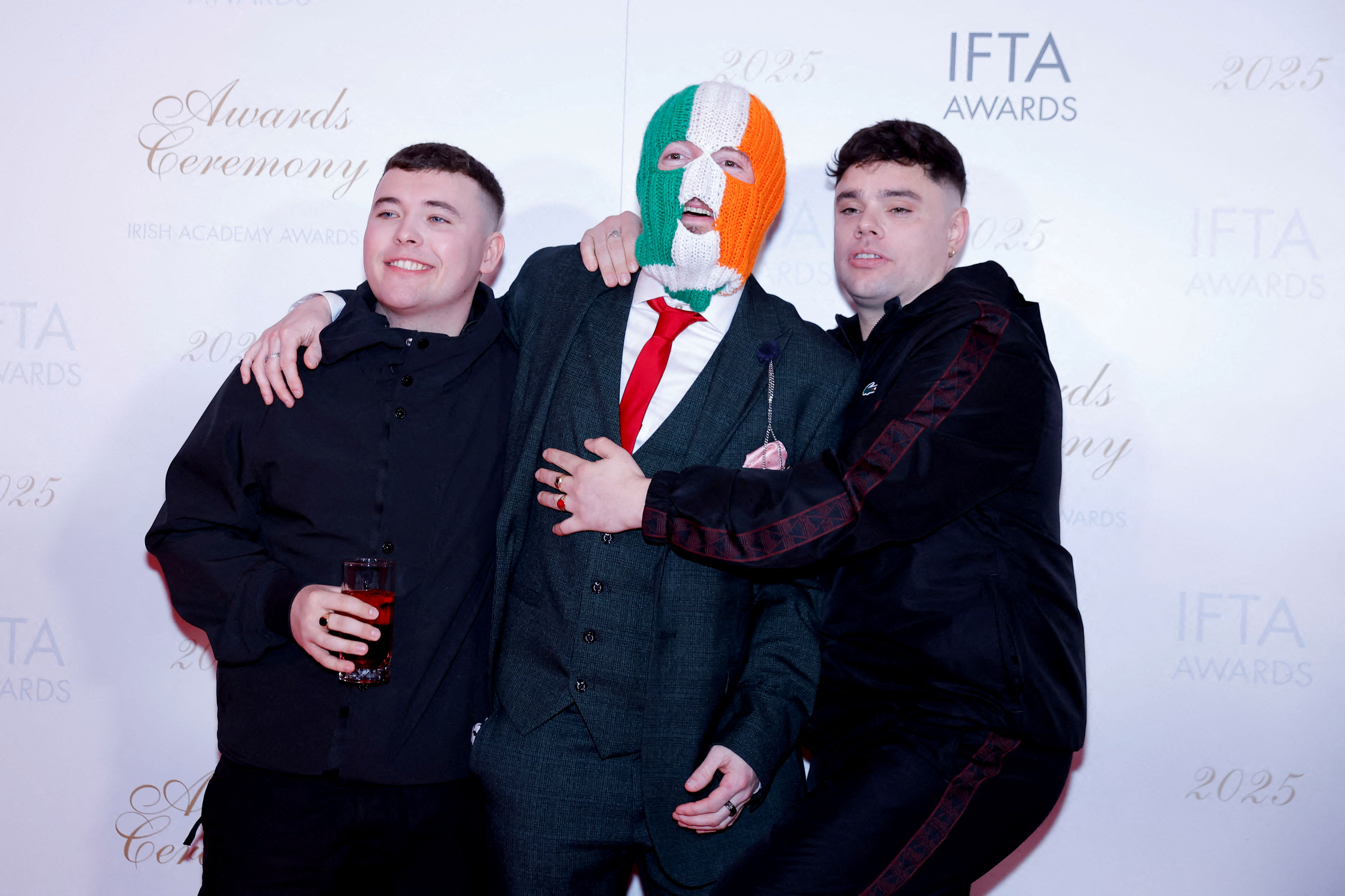 The three members of Kneecap pose on a red carpet