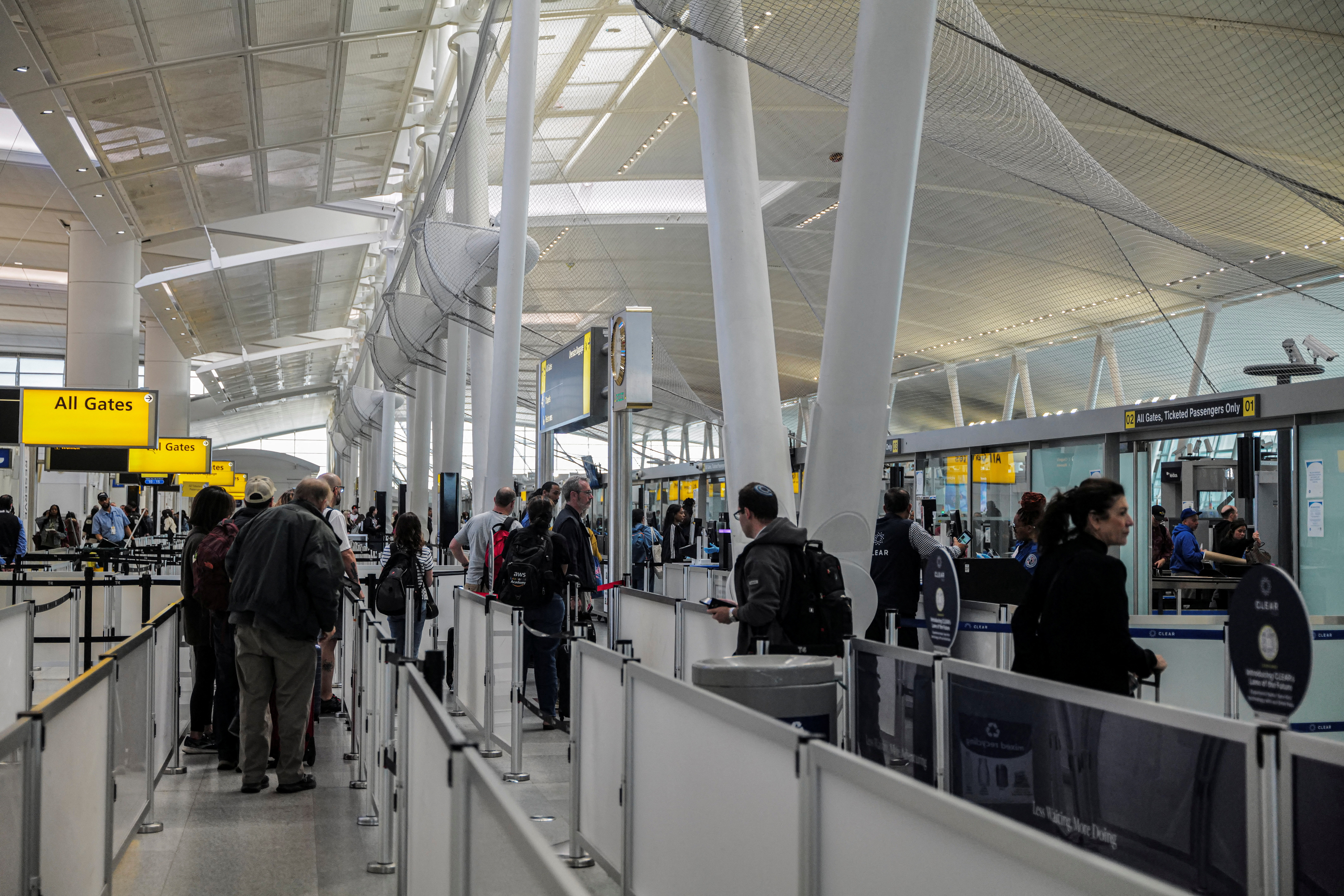 Travellers make their way to a security checkpoint at John F. Kennedy International Airport (JFK) in New York City, U.S., May 7, 2025. REUTERS/Jeenah Moon