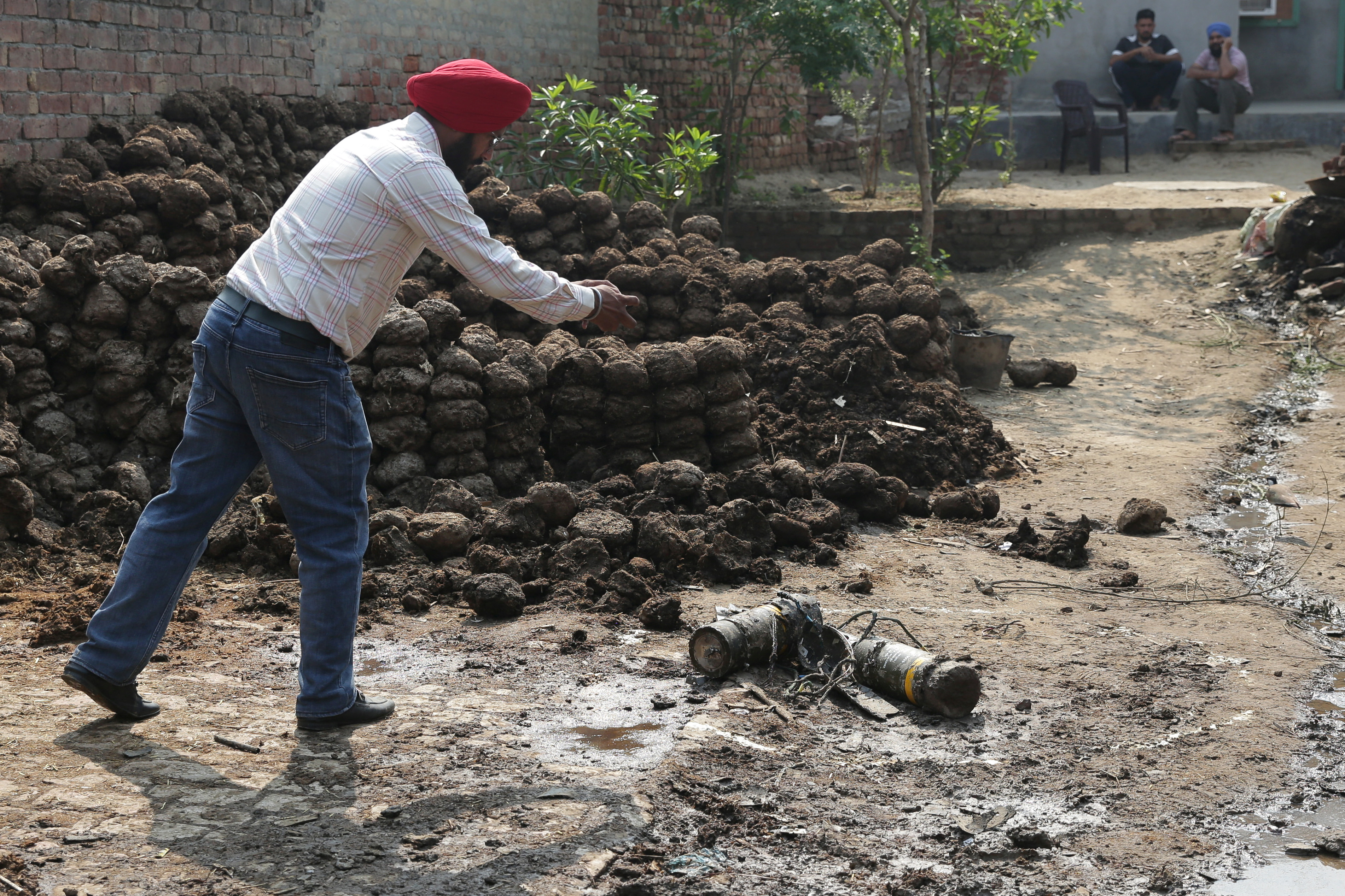 A man takes photographs of projectile debris in a courtyard of a residential house, following Pakistani military attacks, at Wadala Bhitewadh village near Amritsar, India, on May 10, 2025