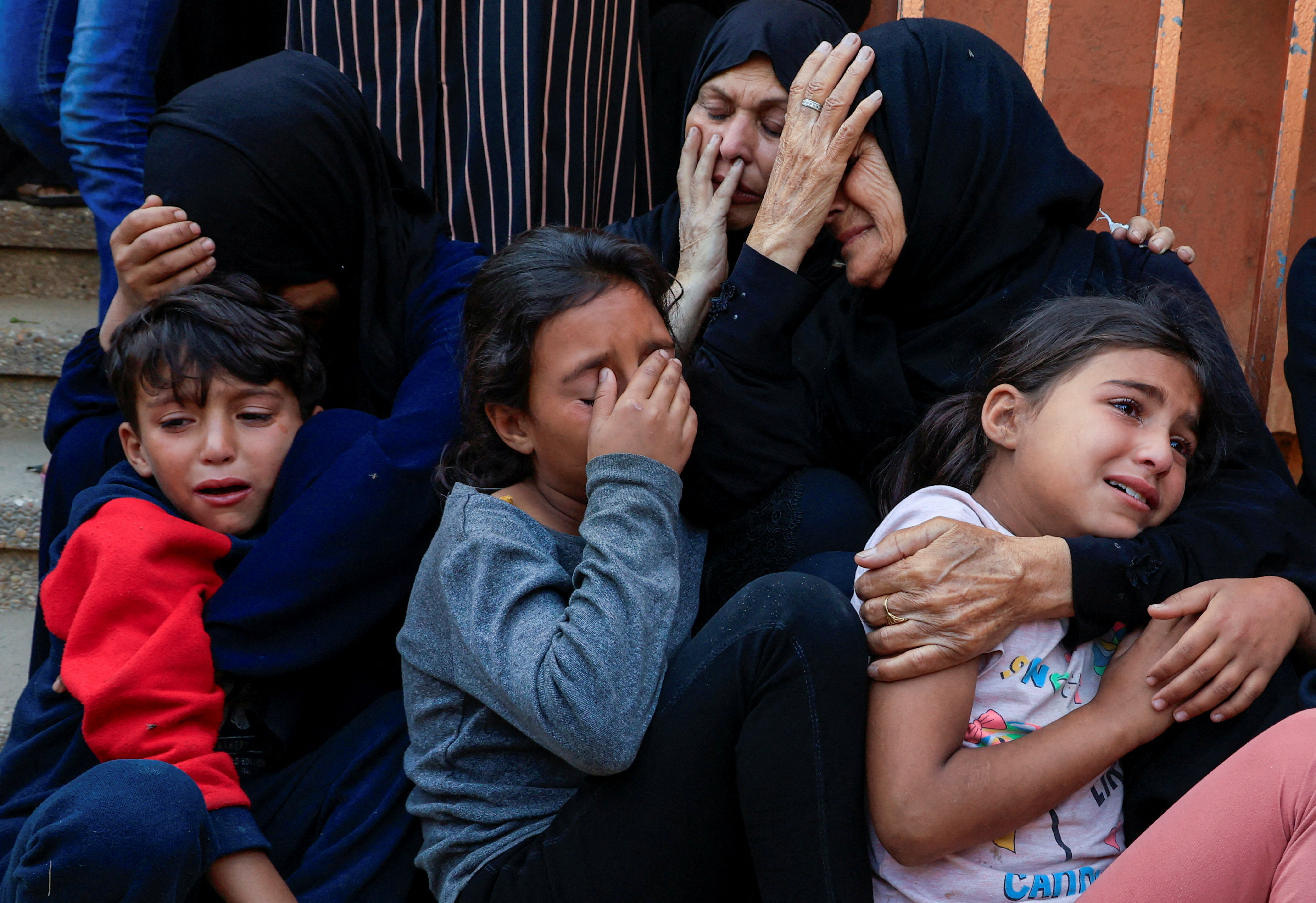 Mourners react during the funeral of Palestinians killed in Israeli strikes