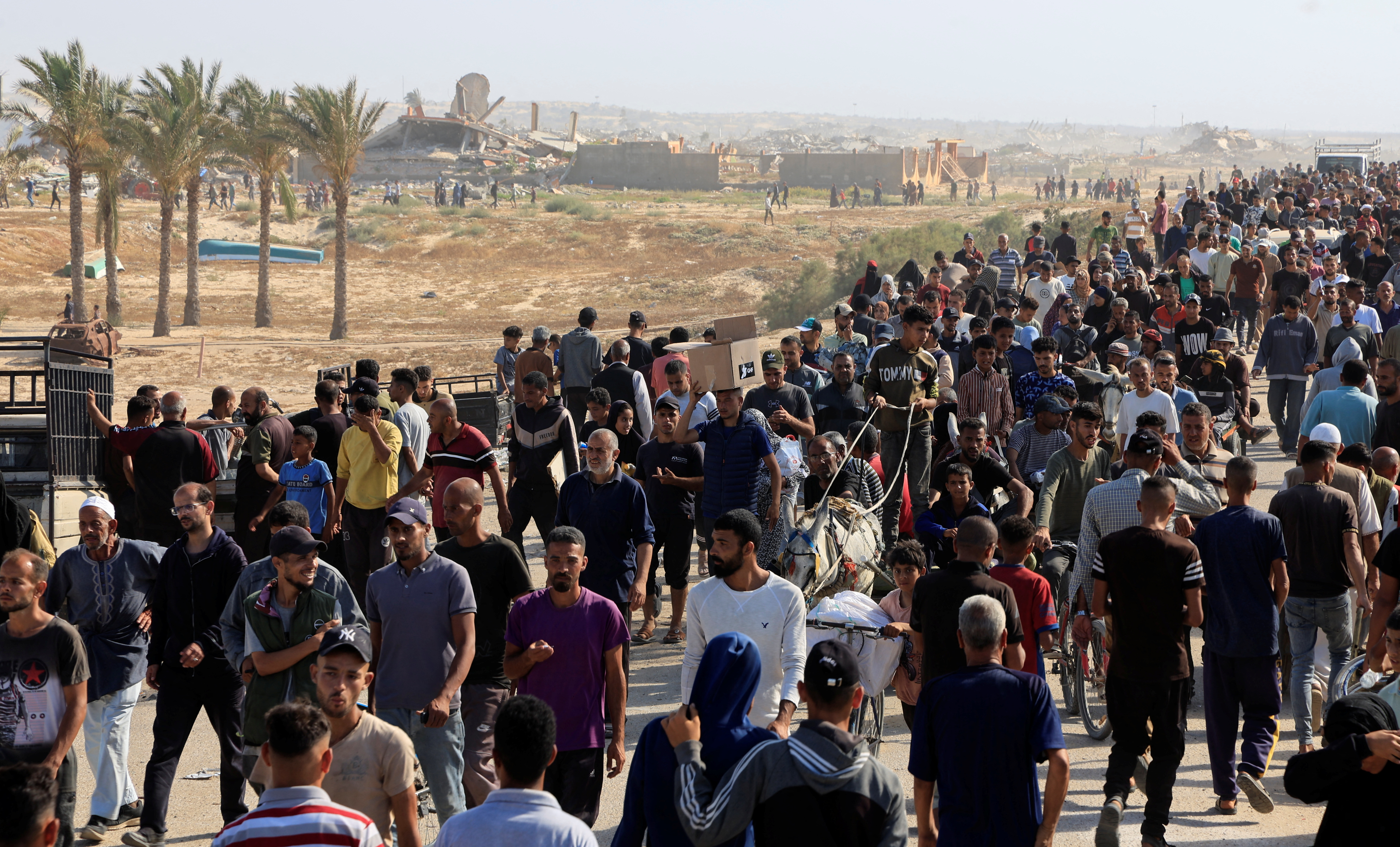 Crowds of thousands gather on a road as they seek supplies in southern Gaza.