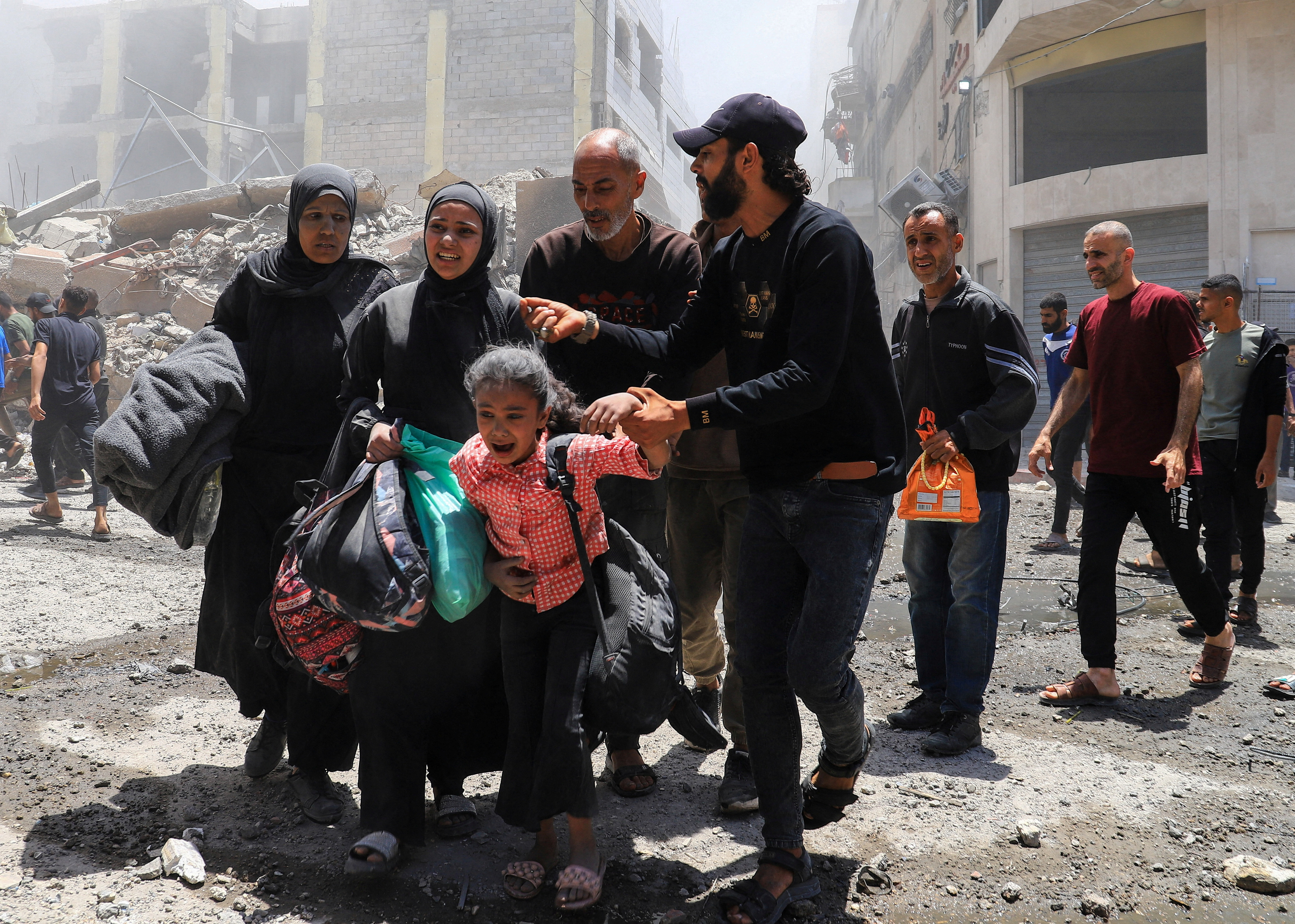 Palestinians evacuate in the aftermath of an Israeli strike on a house, in Gaza City