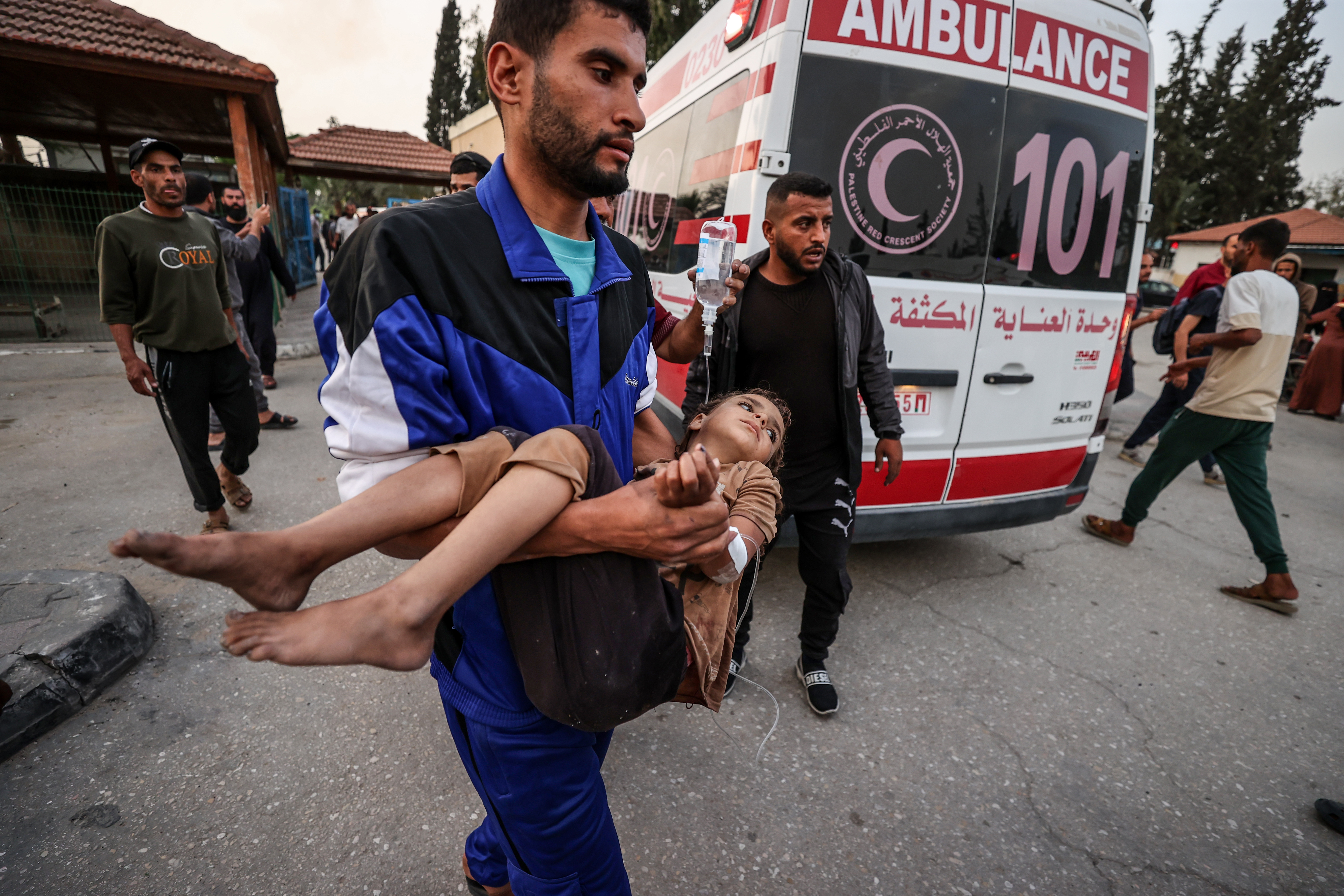 A man carries an injured child.