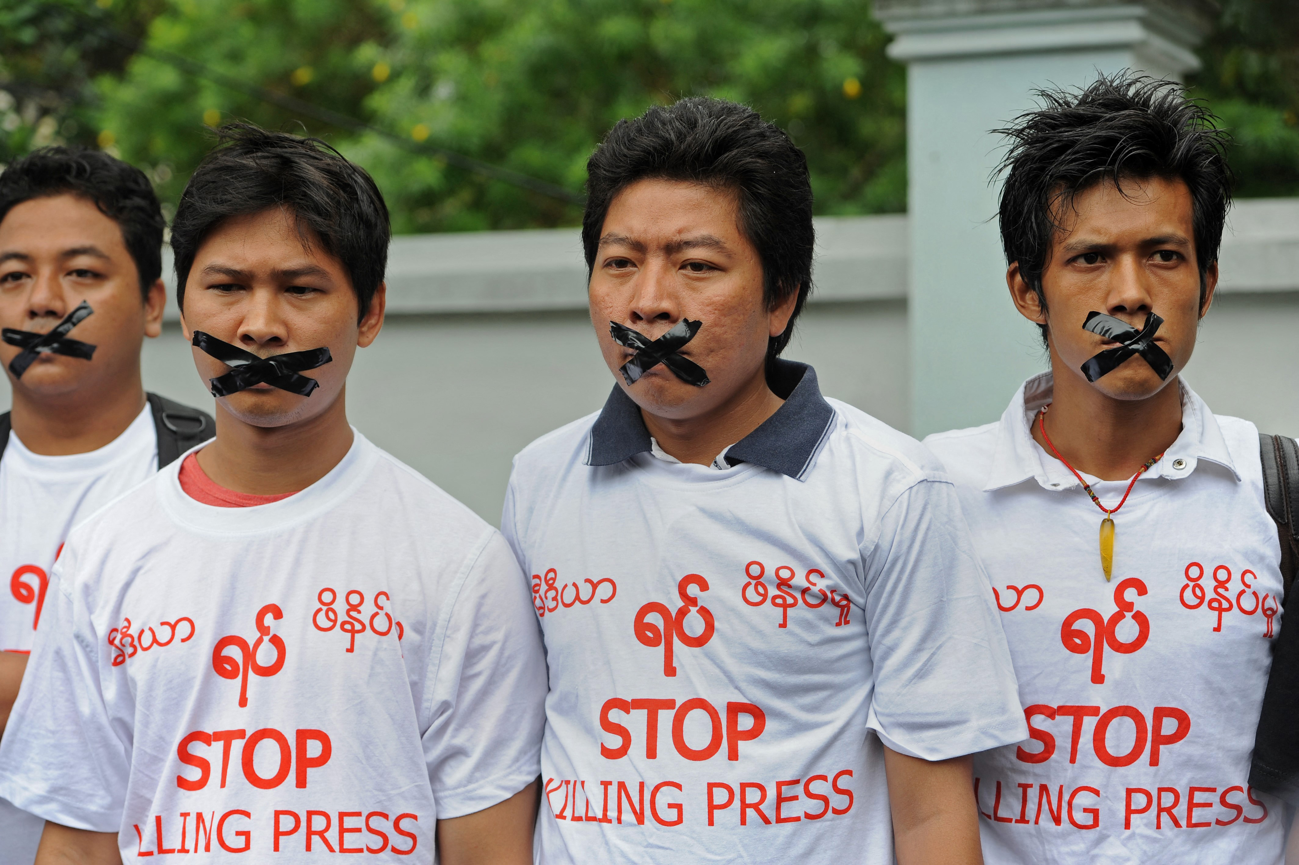 Myanmar journalists wearing T-shirts that say "Stop Killing Press" stage a silent protest for five journalists who were jailed for 10 years on July 10, near the Myanmar Peace Center where Myanmar President Thein Sein was scheduled to meet with local artists in Yangon on July 12, 2014. Myanmar jailed five journalists to 10 years in prison with hard labour on July 10 over a report accusing the military of producing chemical weapons, a sentence denounced by campaigners as "outrageously harsh". Reporters Without Borders described the verdict as "very worrying for press freedom" in Myanmar. AFP PHOTO / SOE THAN WIN (Photo by Soe Than WIN / AFP)