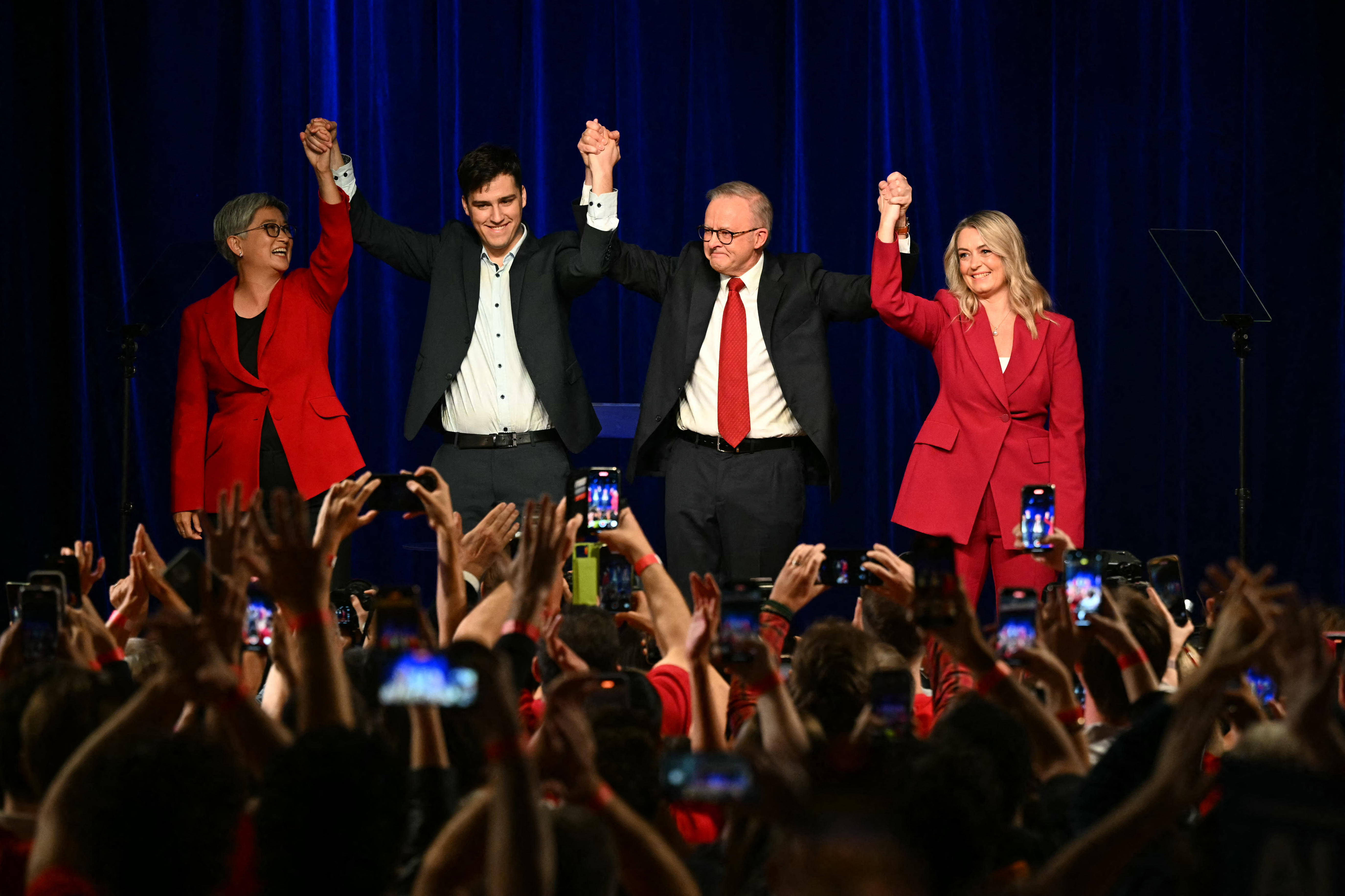 Australia's Prime Minister Anthony Albanese celebrates with his partner Jodie Haydon (R), son Nathan Albanese and Australia's Foreign Minister Penny Wong (L) after winning the general election at the Labor Party election night event in Sydney on May 3, 2025