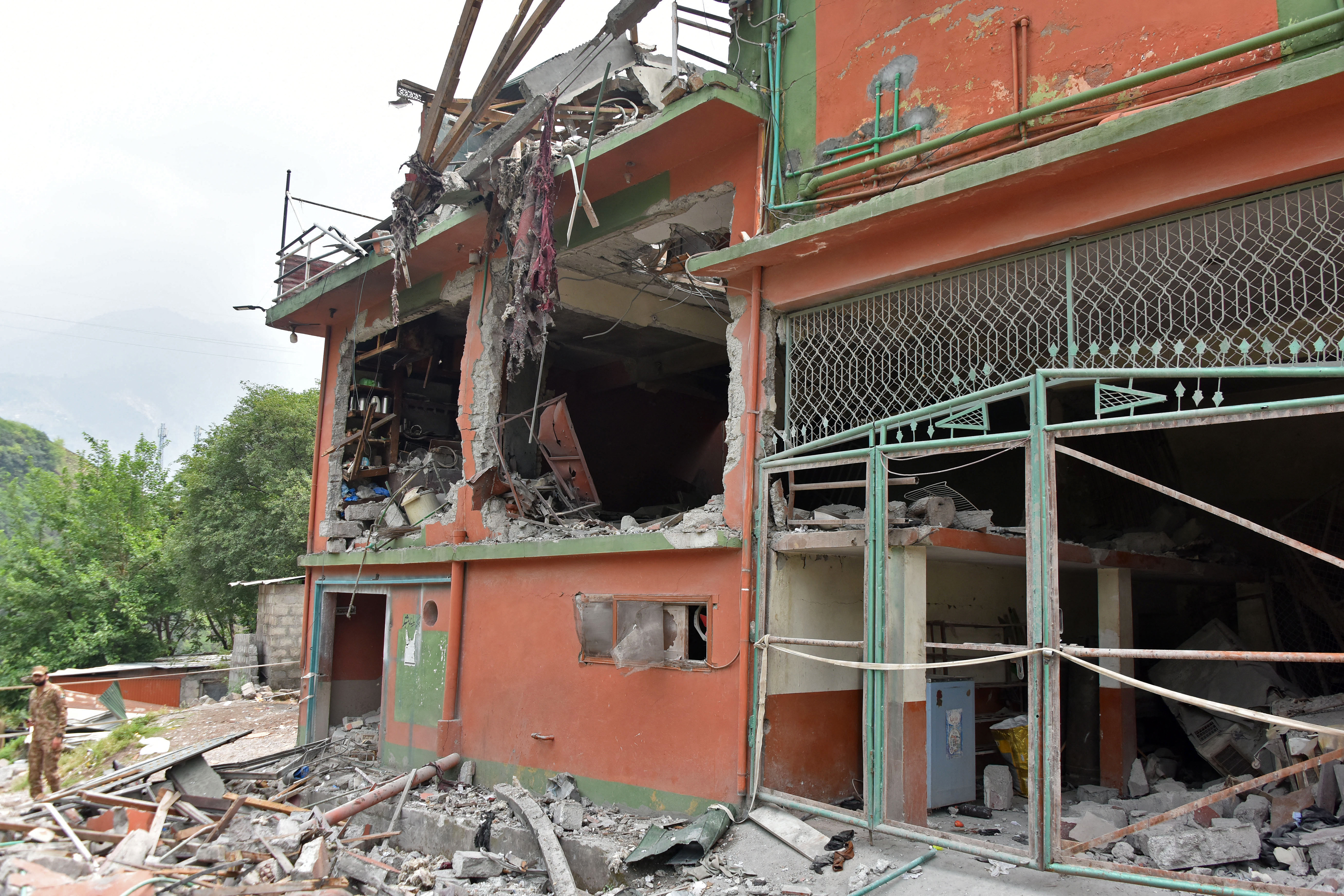 A soldier inspects the debris of a mosque after Indian strikes