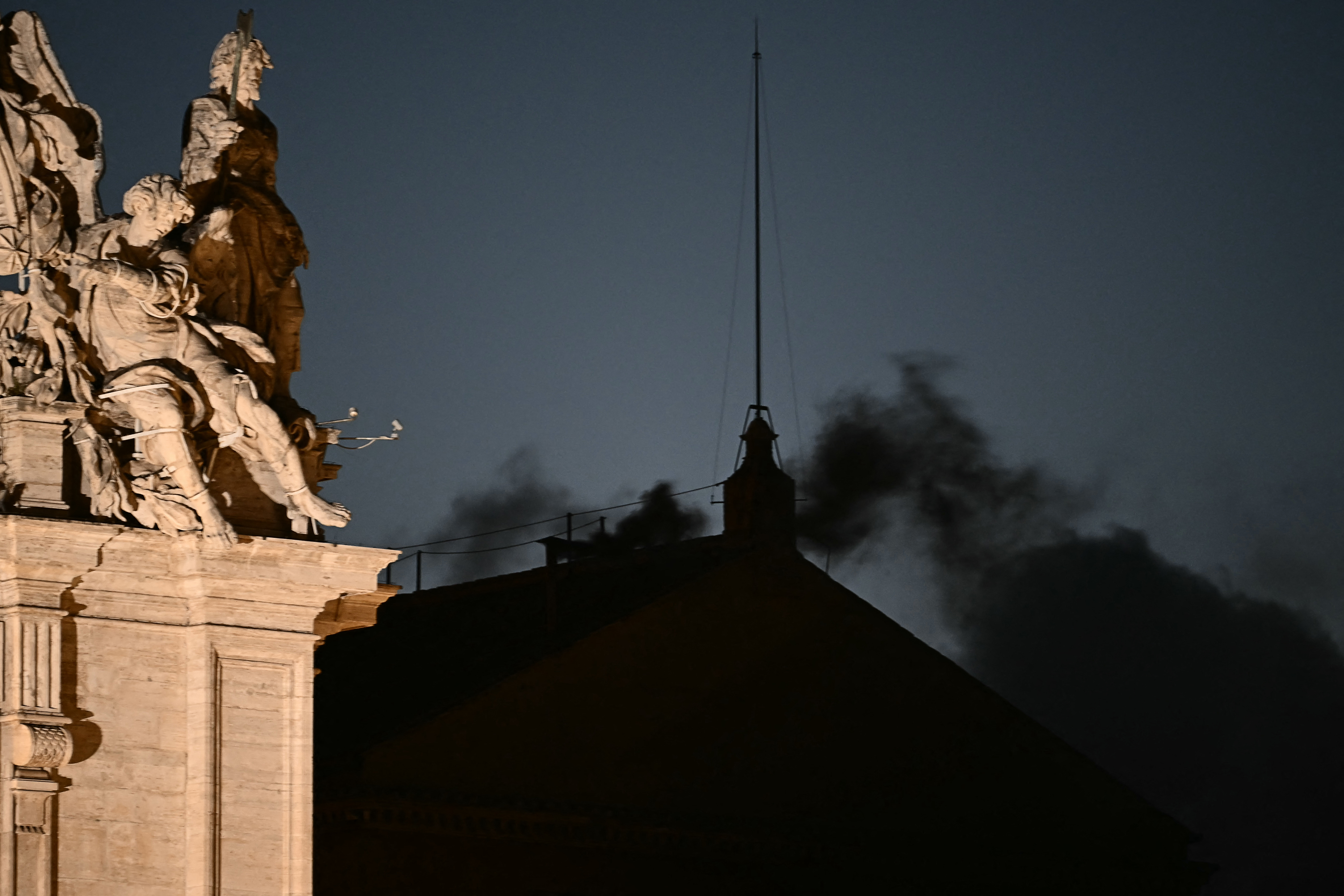 Black smoke rises from the chimney of the Sistine Chapel signalling that cardinals failed to elect a new pope in the first ballot of their conclave in the Vatican on May 7, 2025.