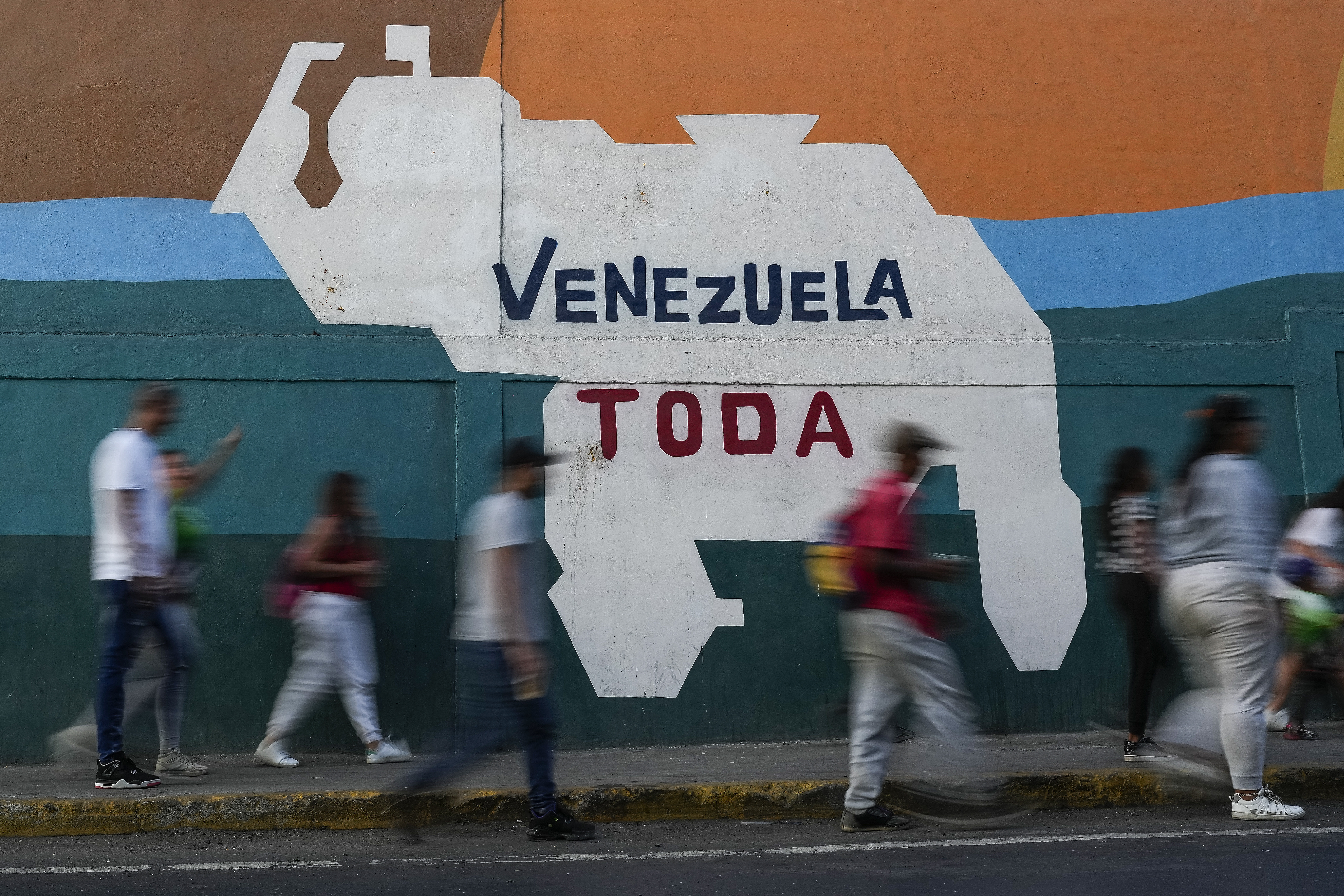 A mural shows the outline of Venezuela with the words "Venezuela Toda"