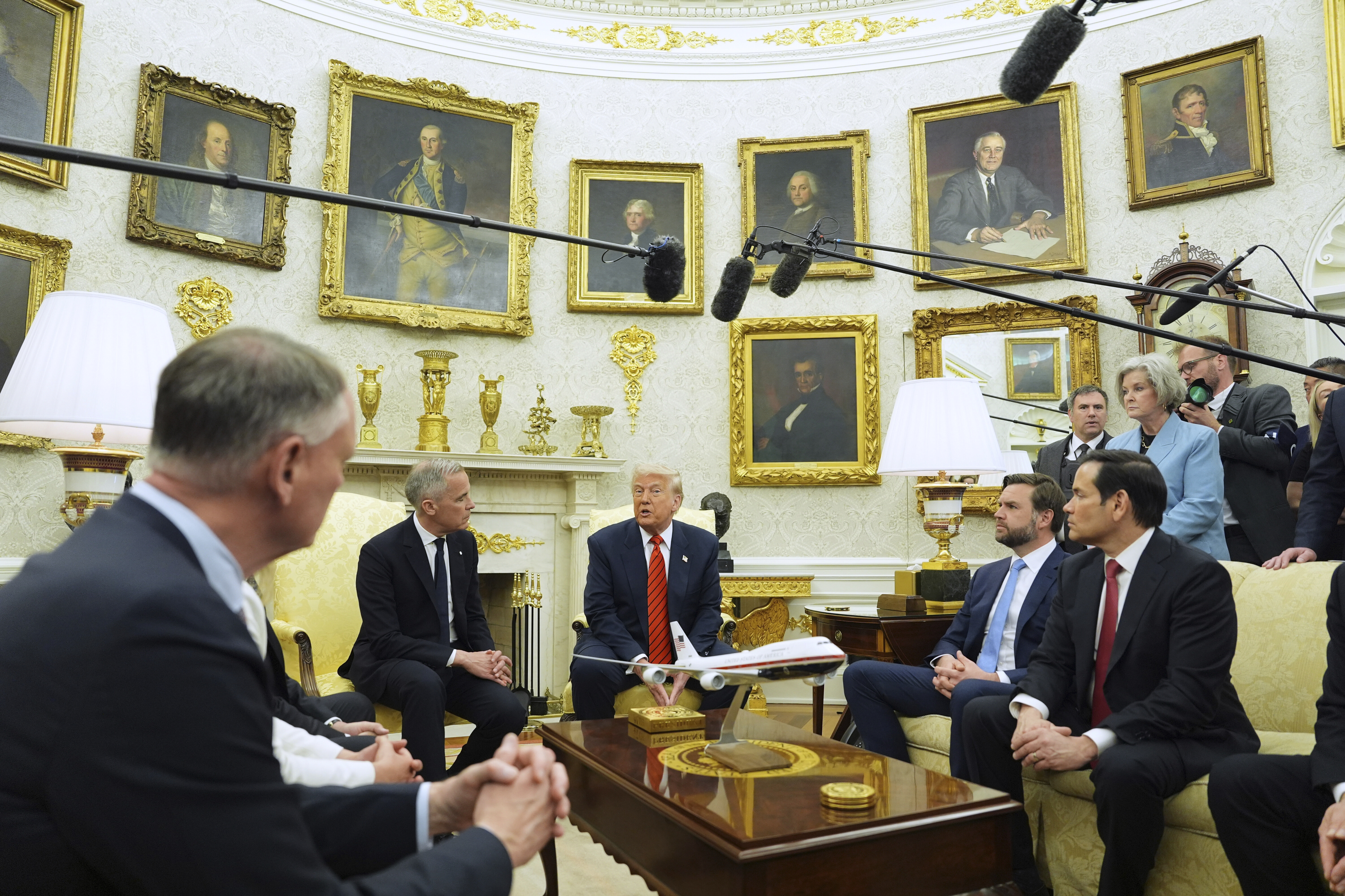 Boom mikes loom over Trump and Mark Carney as they speak in the Oval Office.