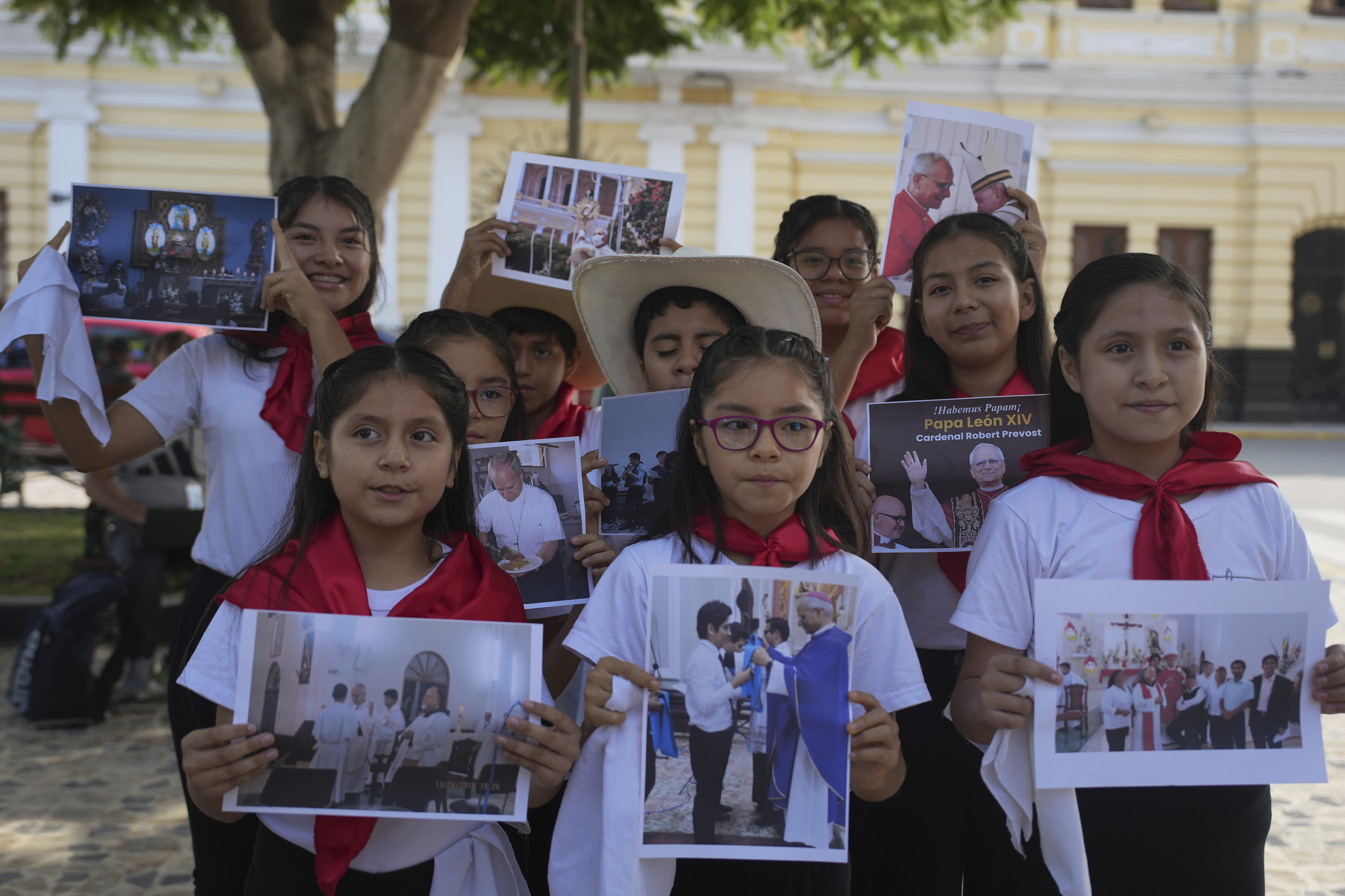 Children hold up pictures of Pope Leo XIV in Peru