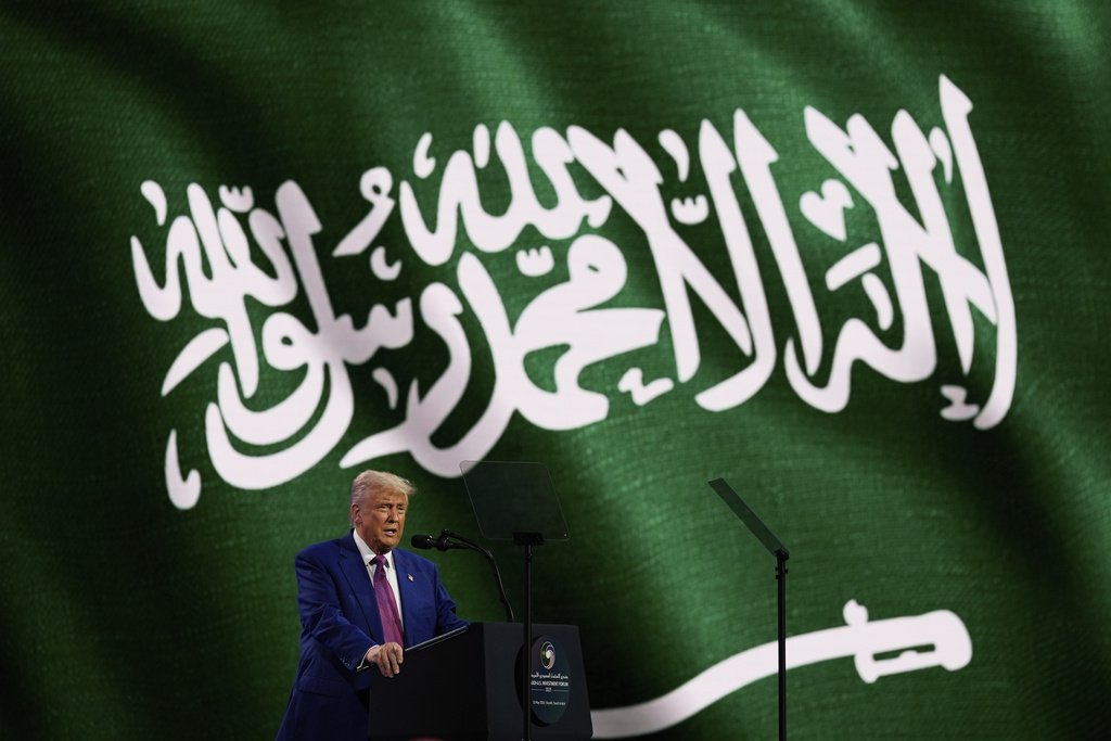 Trump with the Saudi flag behind him