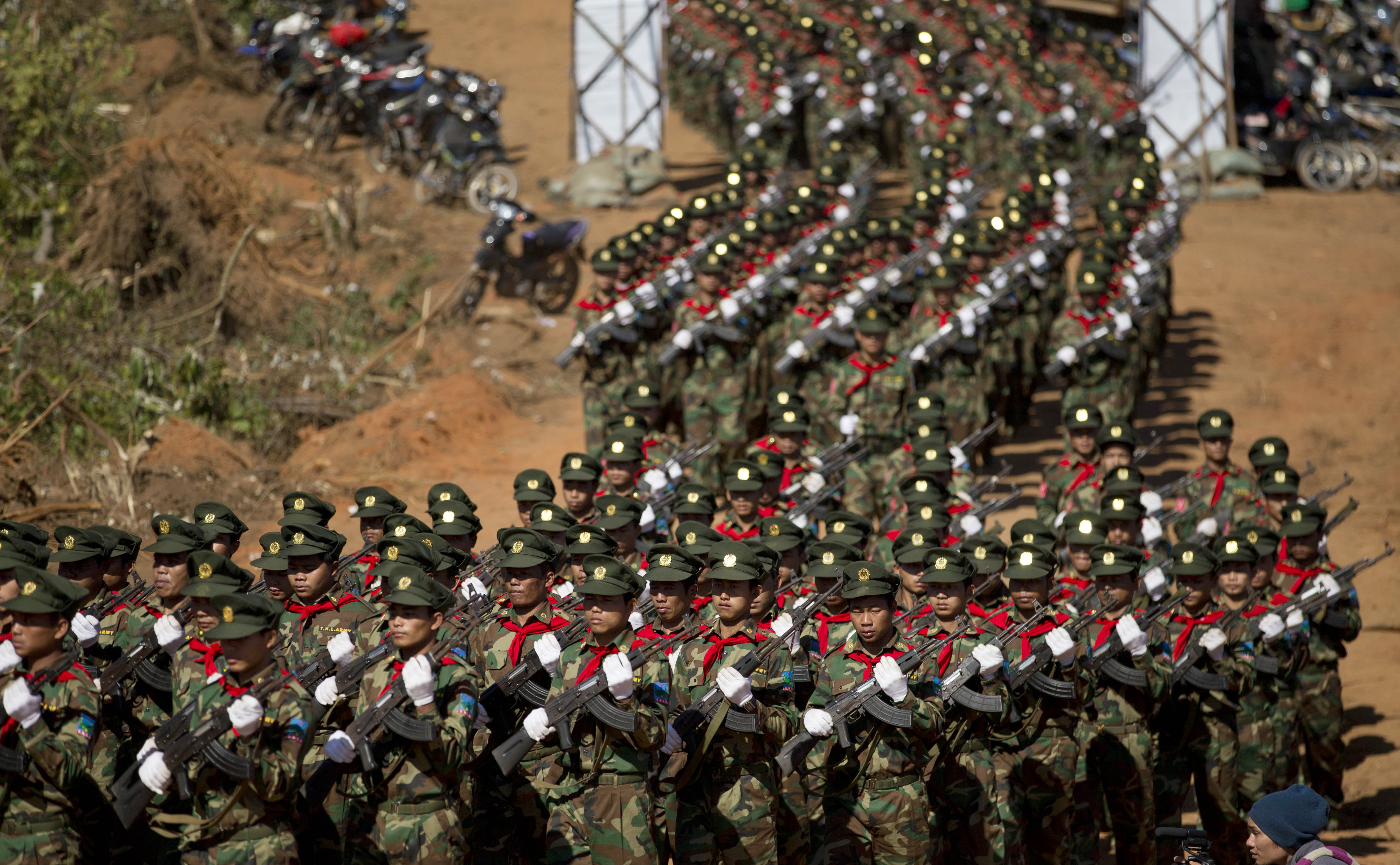 In this Jan. 12, 2015, photo, Taang National Liberation army officers march during a function to mark 52nd Ta'ang revolution day in Mar-Wong, Taang self-governing area, northern Shan state, Myanmar. Despite Aung San Suu Kyi's National League for Democracy party takes over power from a military-dominated regime from April 1, 2016 the Home Ministry, headed by a military-appointed minister, will retain its power over civil administration down to the village level as well as the police and domestic espionage.(AP Photo/Gemunu Amarasinghe)