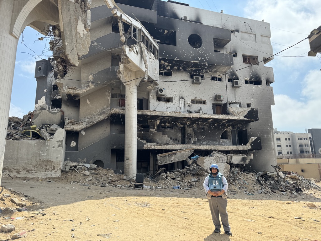 A man in front of a burned hospital building