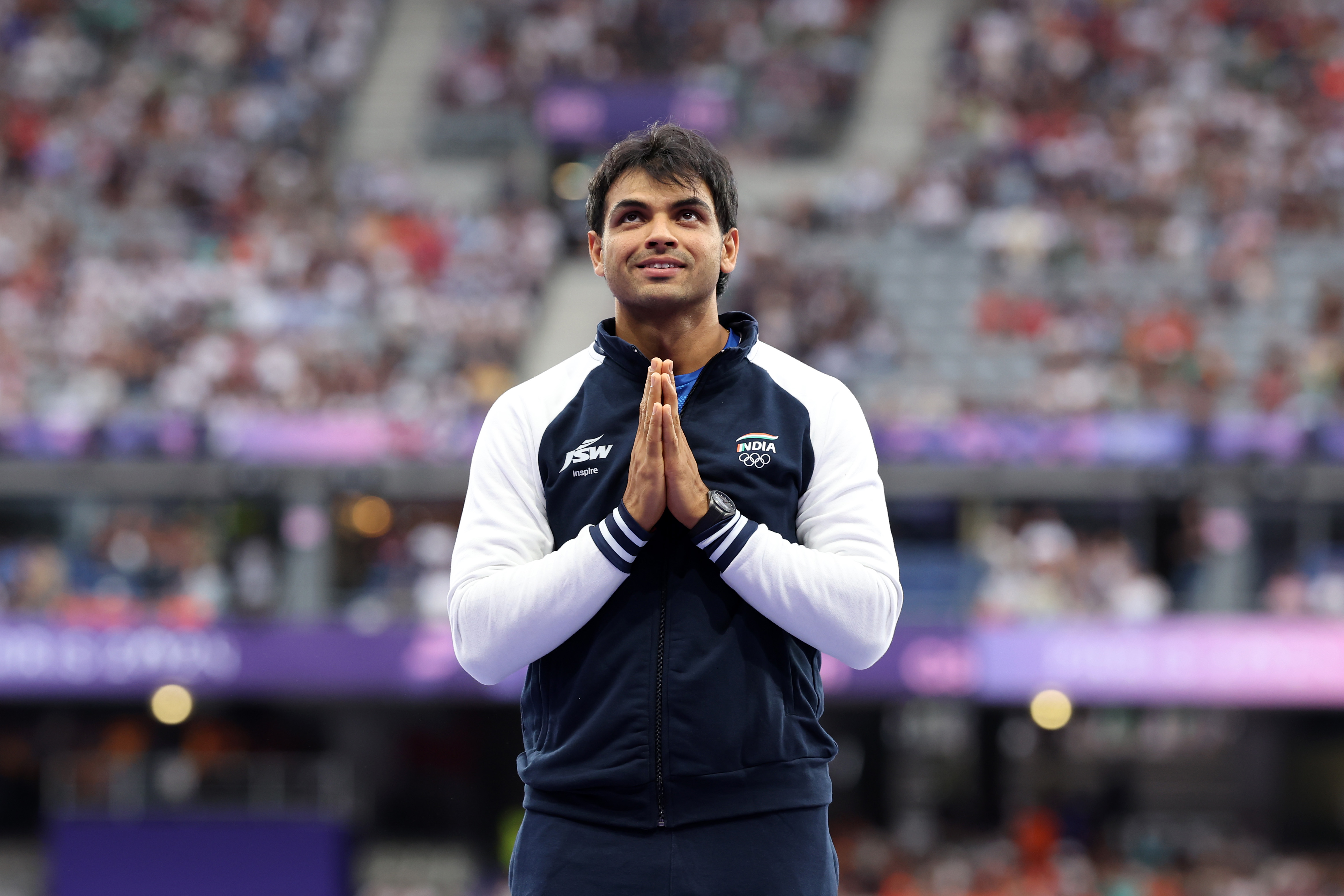 PARIS, FRANCE - AUGUST 09: Silver medalist Neeraj Chopra of Team India celebrates on the podium during the Men's 110m Hurdles ceremony on day fourteen of the Olympic Games Paris 2024 at Stade de France on August 09, 2024 in Paris, France. (Photo by Christian Petersen/Getty Images)