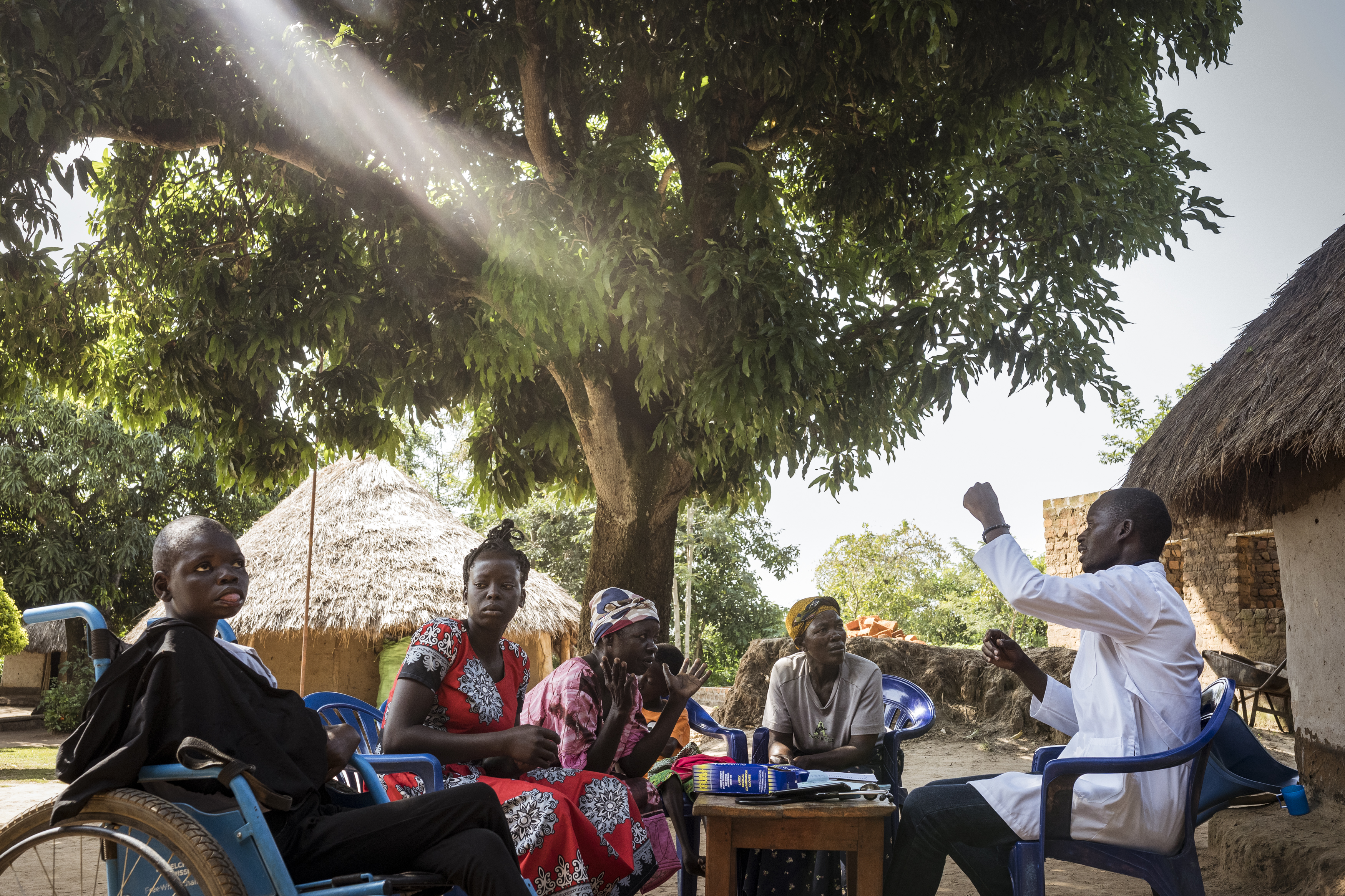 Obule Lira, Soroti District, Uganda. Dr. Sam Ecengu, a local GP offers advice to the mother of 19-year-old Kahna Ikiro, Edith Abuno, at a community outreach run by Cherish Ikoku Uganda. The outreach program is an important component in the battle against cultural stigma surrounding disability. The hope is that the knowledge is taken back to their villages and shared amongst the community. [Christopher Hopkins/Al Jazeera]