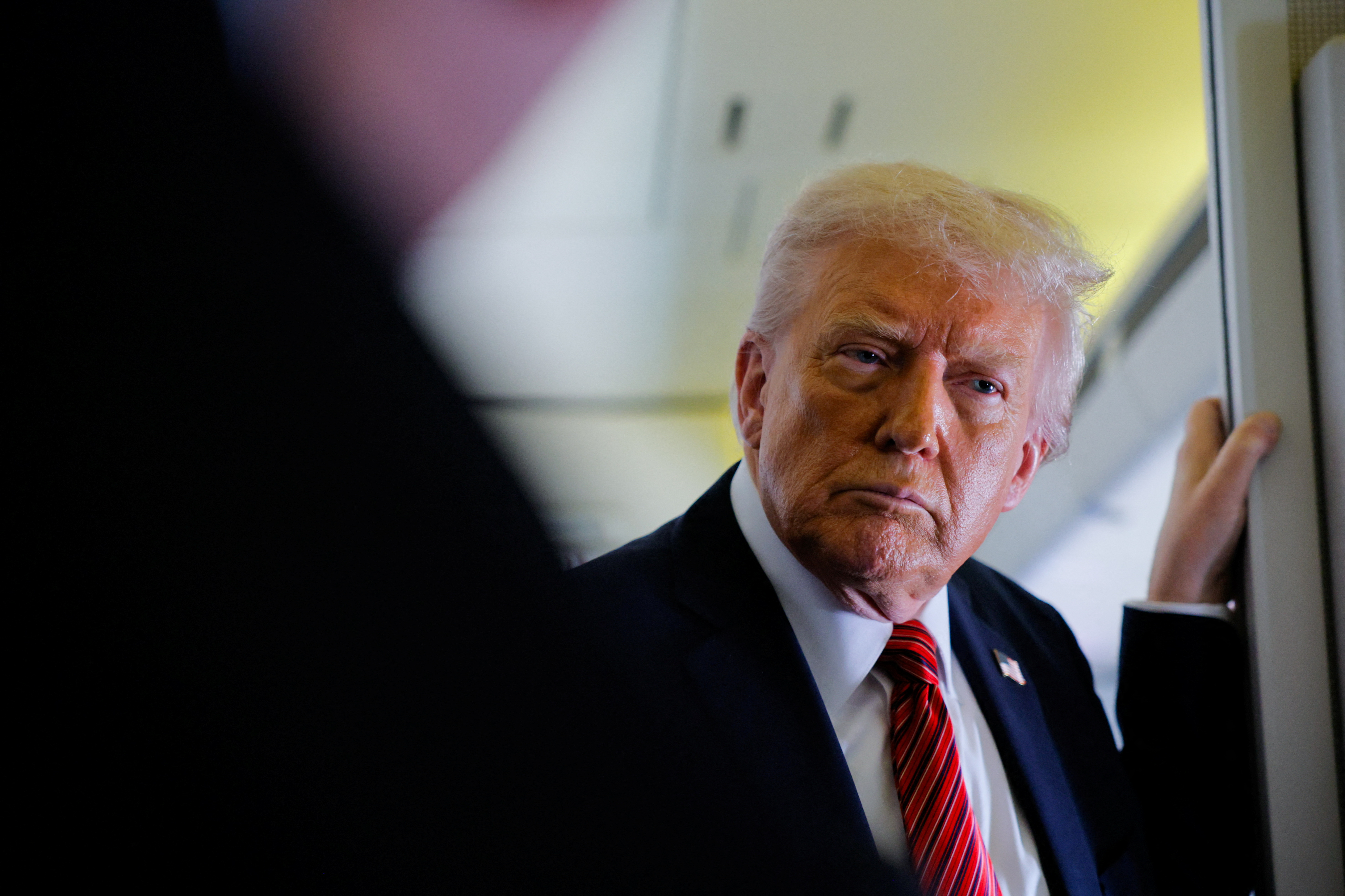 U.S. President Donald Trump looks on as he speaks to the press on board Air Force One en route to Doha, Qatar, May 14, 2025. REUTERS/Brian Snyder