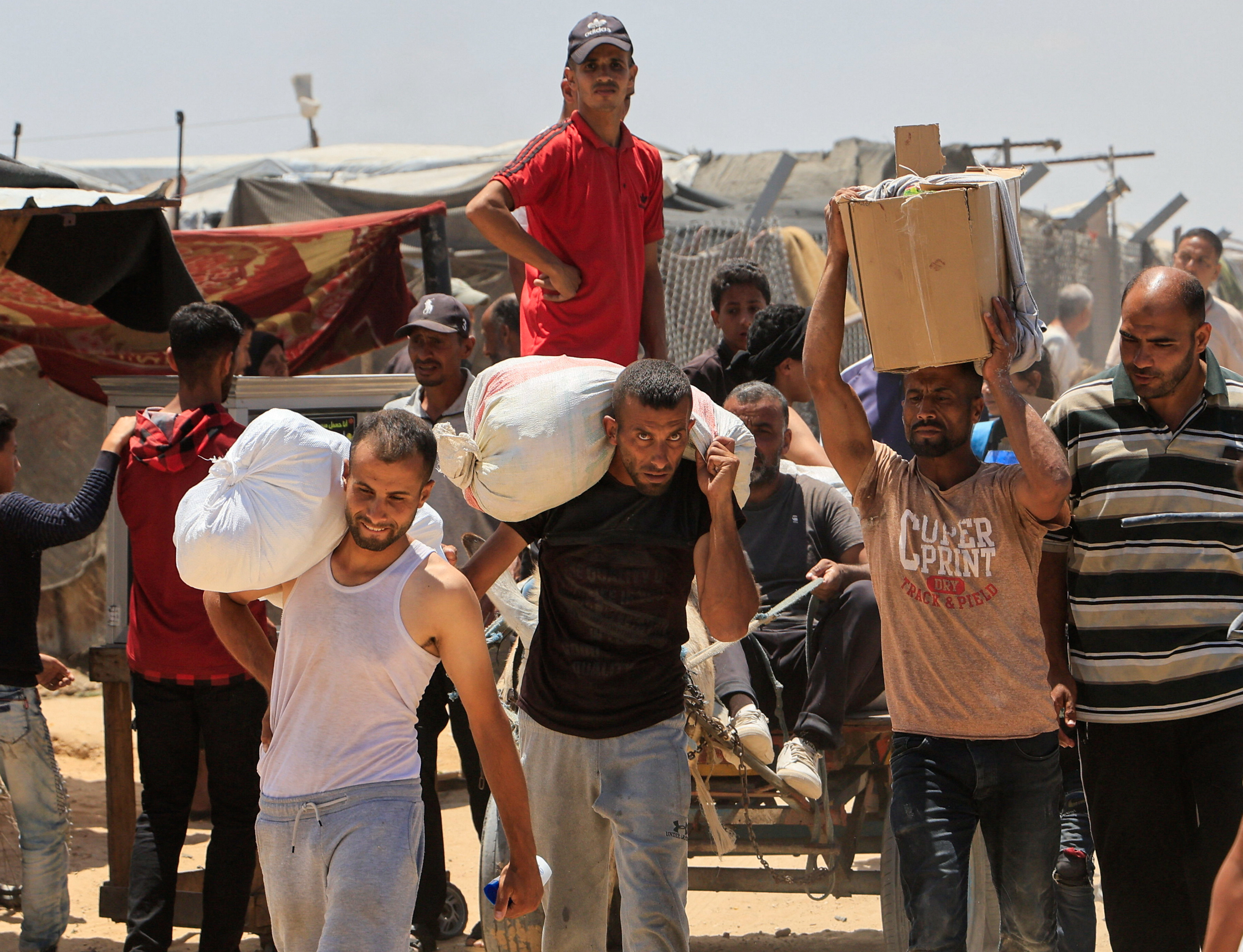 Palestinians carry aid supplies they received from the U.S.-backed Gaza Humanitarian Foundation, in Khan Younis, in the southern Gaza Strip, May 28, 2025. REUTERS/Hatem Khaled