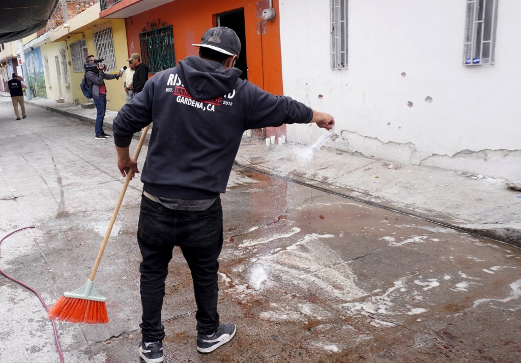 A man cleans stains of blood after a shooting at the Barrio Nuevo neighbourhood in Irapuato, Guanajuato state, Mexico, on June 25, 2025. 
