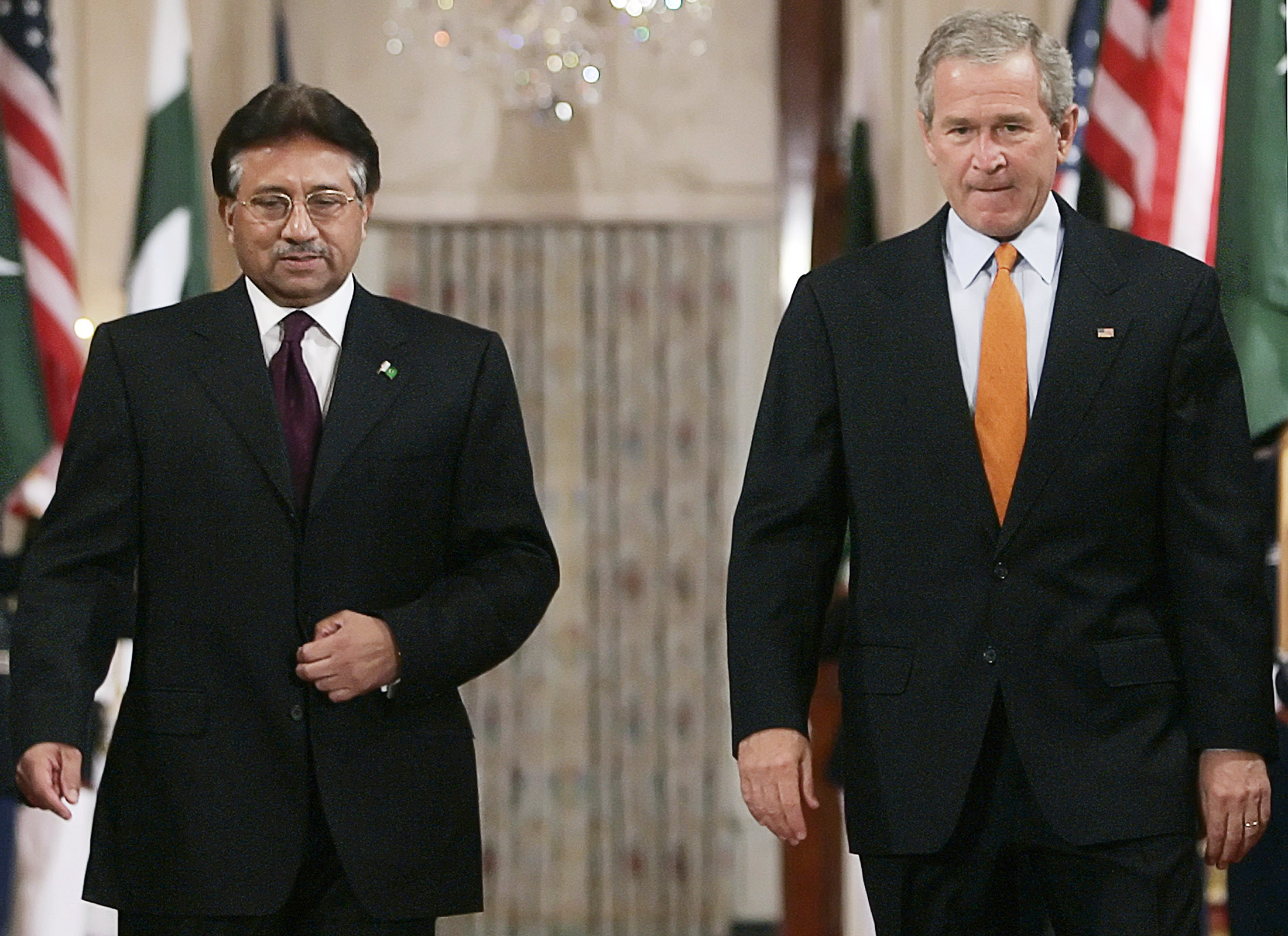 U.S. President George W. Bush (R) walks to a joint news conference with Pakistan President Pervez Musharraf in the East Room at the White House in Washington, September 22, 2006. REUTERS/Jim Young (UNITED STATES)