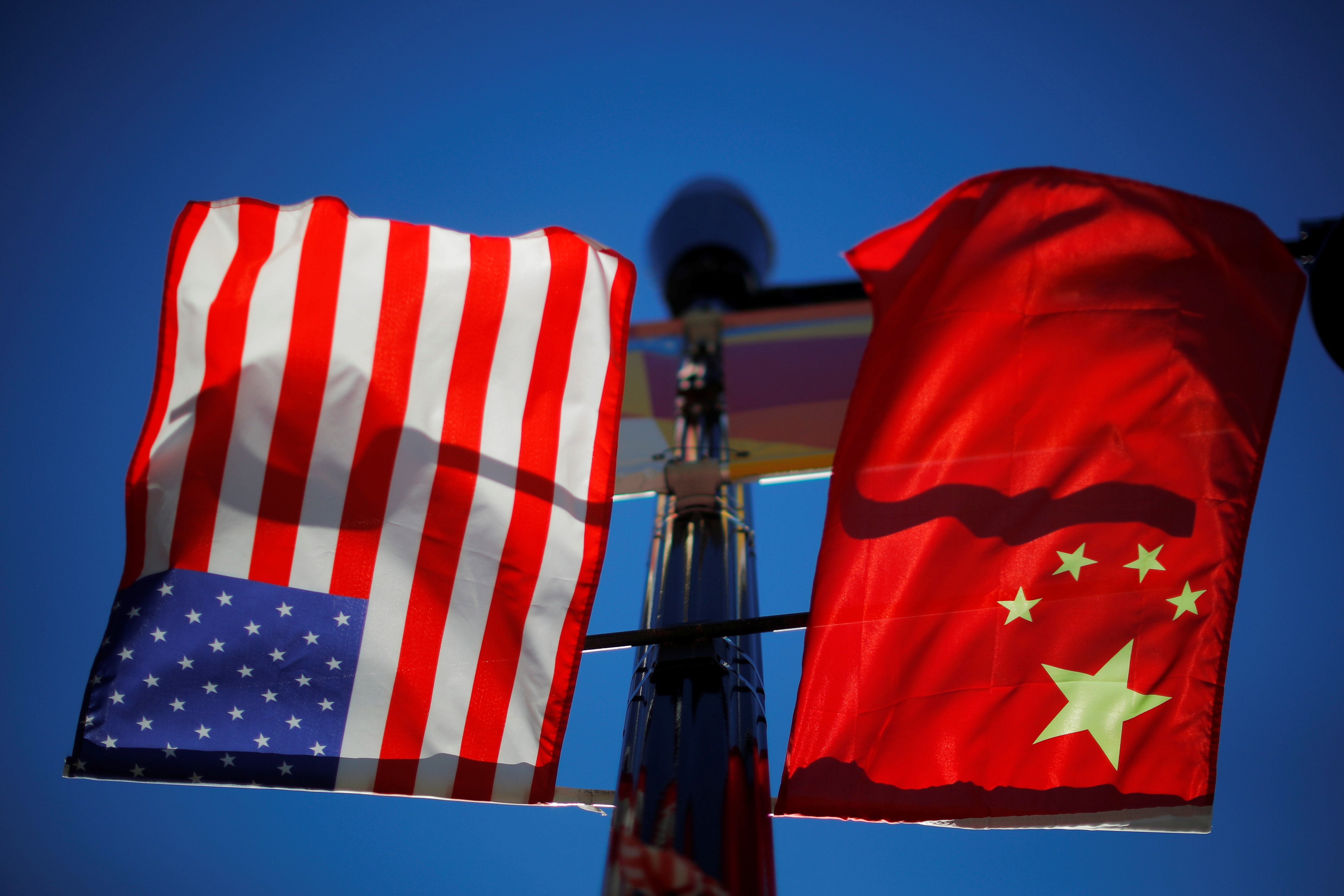 The flags of the United States and China fly from a lamppost in the Chinatown neighborhood of Boston, Massachusetts, U.S., November 1, 2021. REUTERS/Brian Snyder