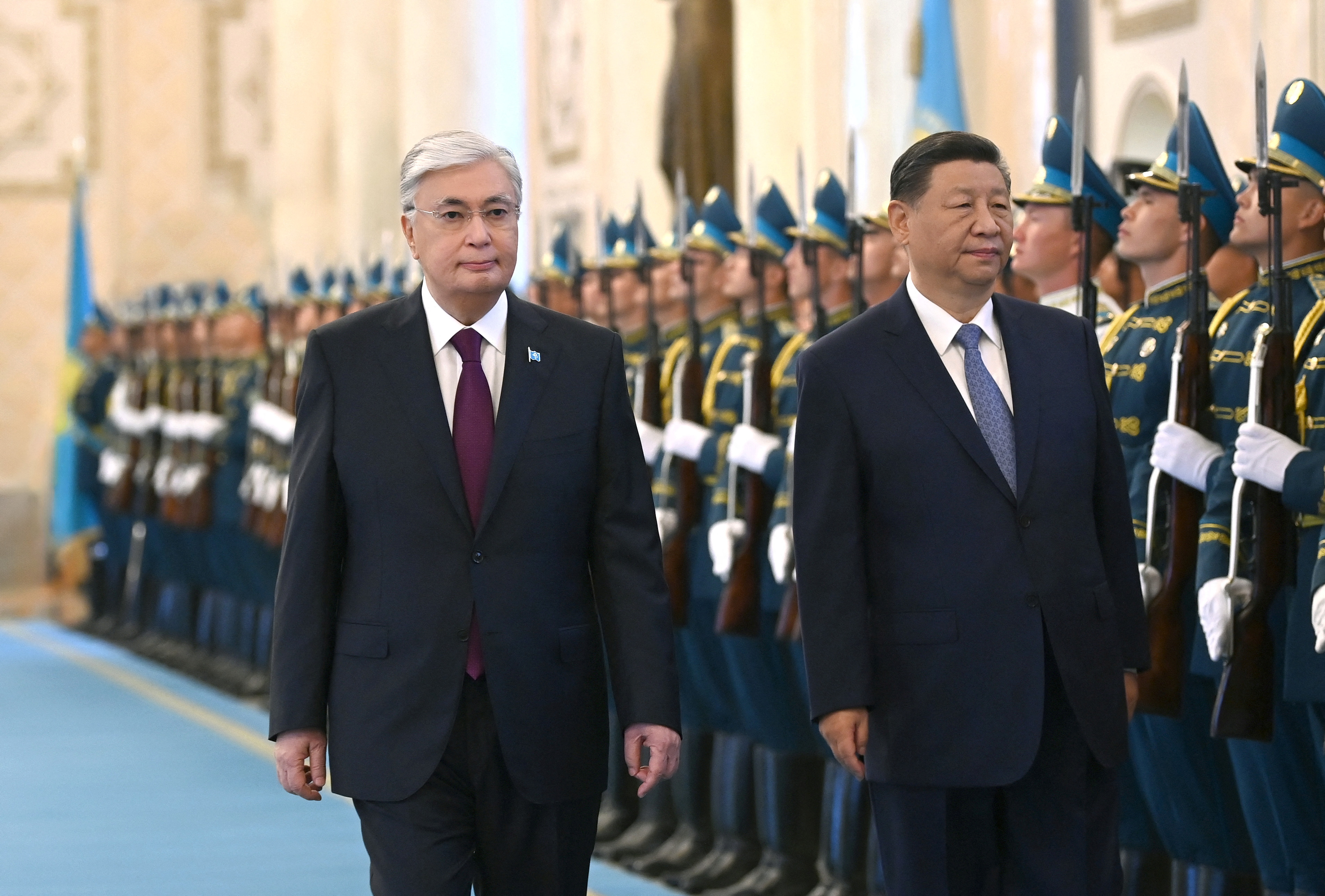 Kazakhstan's President Kassym-Jomart Tokayev and China's President Xi Jinping walk past honour guards during a welcoming ceremony before their talks in Astana, Kazakhstan July 3, 2024. Press Service of the President of Kazakhstan/Handout via REUTERS ATTENTION EDITORS - THIS IMAGE HAS BEEN SUPPLIED BY A THIRD PARTY. MANDATORY CREDIT.