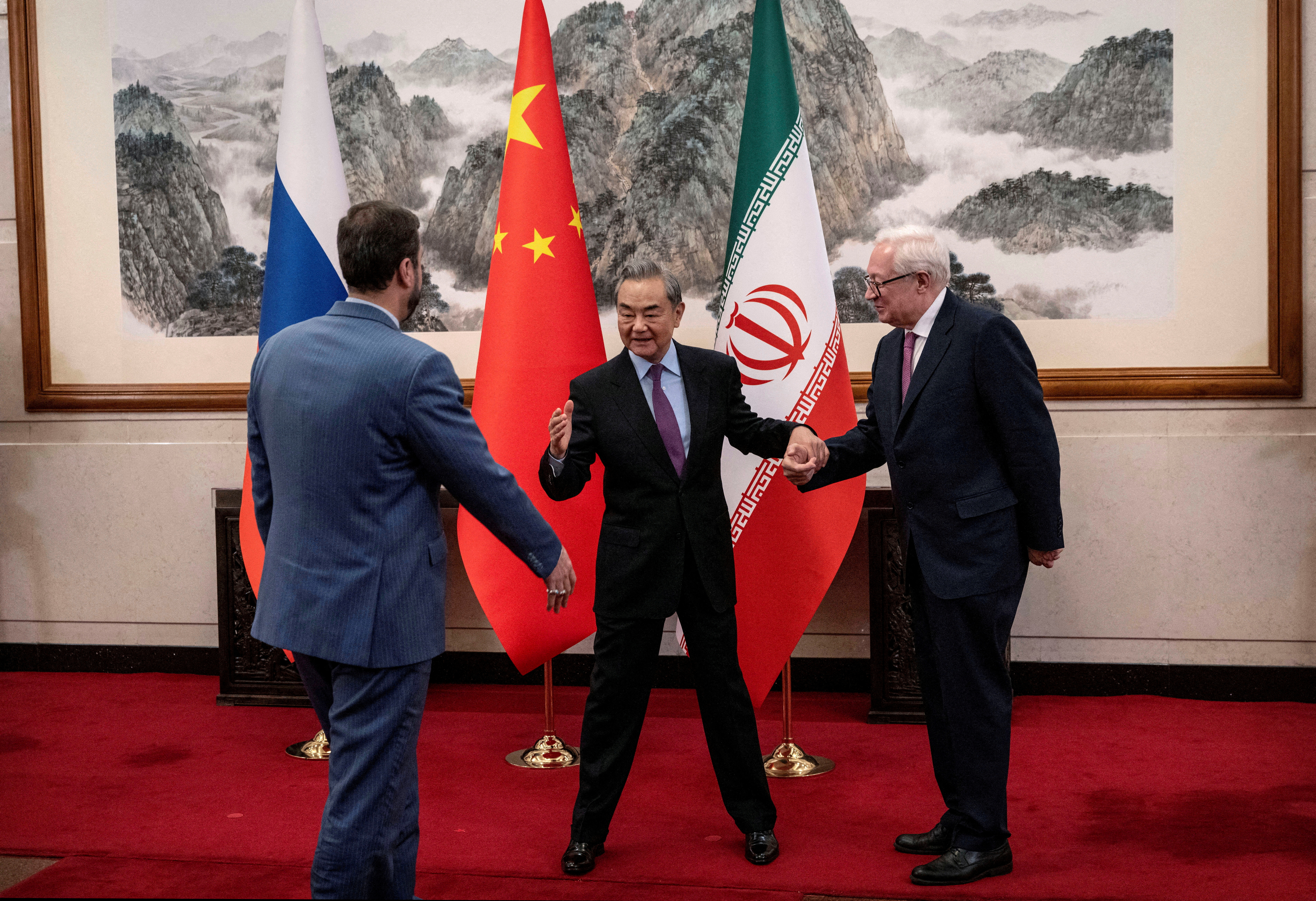 Chinese Foreign Minister Wang Yi welcomes Russian Deputy Foreign Minister Sergey Ryabkov and Iranian Deputy Foreign Minister Kazem Gharibabadi, before a meeting regarding the Iranian nuclear issue at Diaoyutai State Guest House on March 14, 2025, in Beijing, China. Pool via REUTERS TPX IMAGES OF THE DAY REFILE - CORRECTING NAMES FROM "WAG YI" TO "WANG YI" AND "KAZEEM GHARIBABADI" TO "KAZEM GHARIBABADI