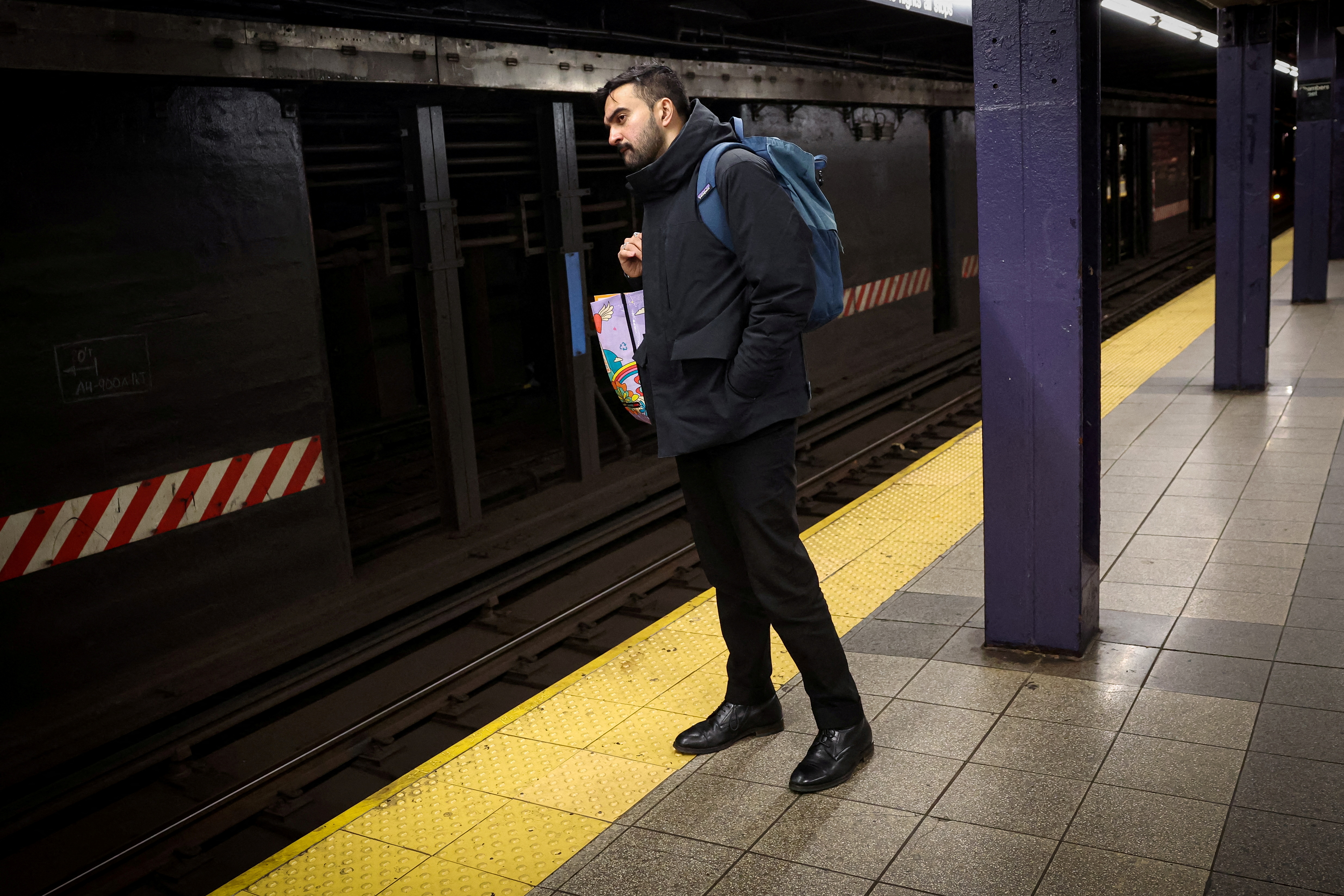 Mamdani in dark jacket at subway station