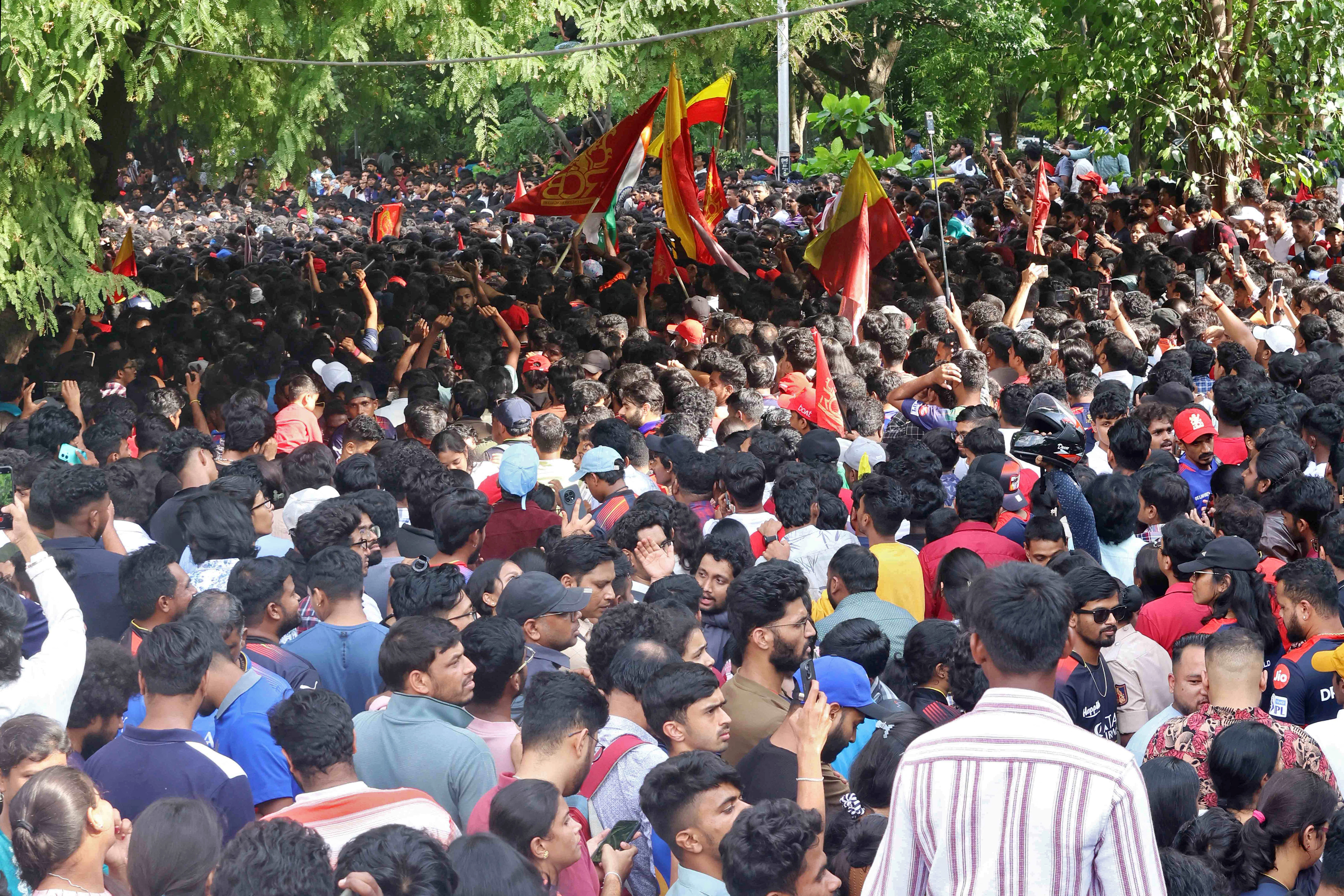 People gather to celebrate Royal Challengers Bengaluru's first IPL title win, outside a cricket stadium in Bengaluru