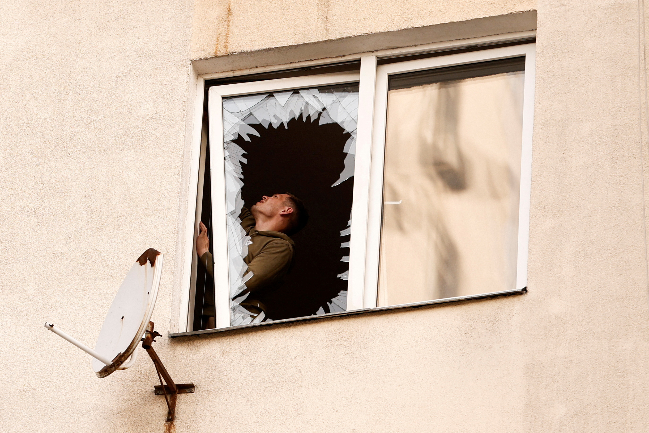 A man inspects damage next to a shattered window at the site of a Russian strike, amid Russia's attack on Ukraine, in Kyiv, Ukraine June 6, 2025. REUTERS/Thomas Peter TPX IMAGES OF THE DAY