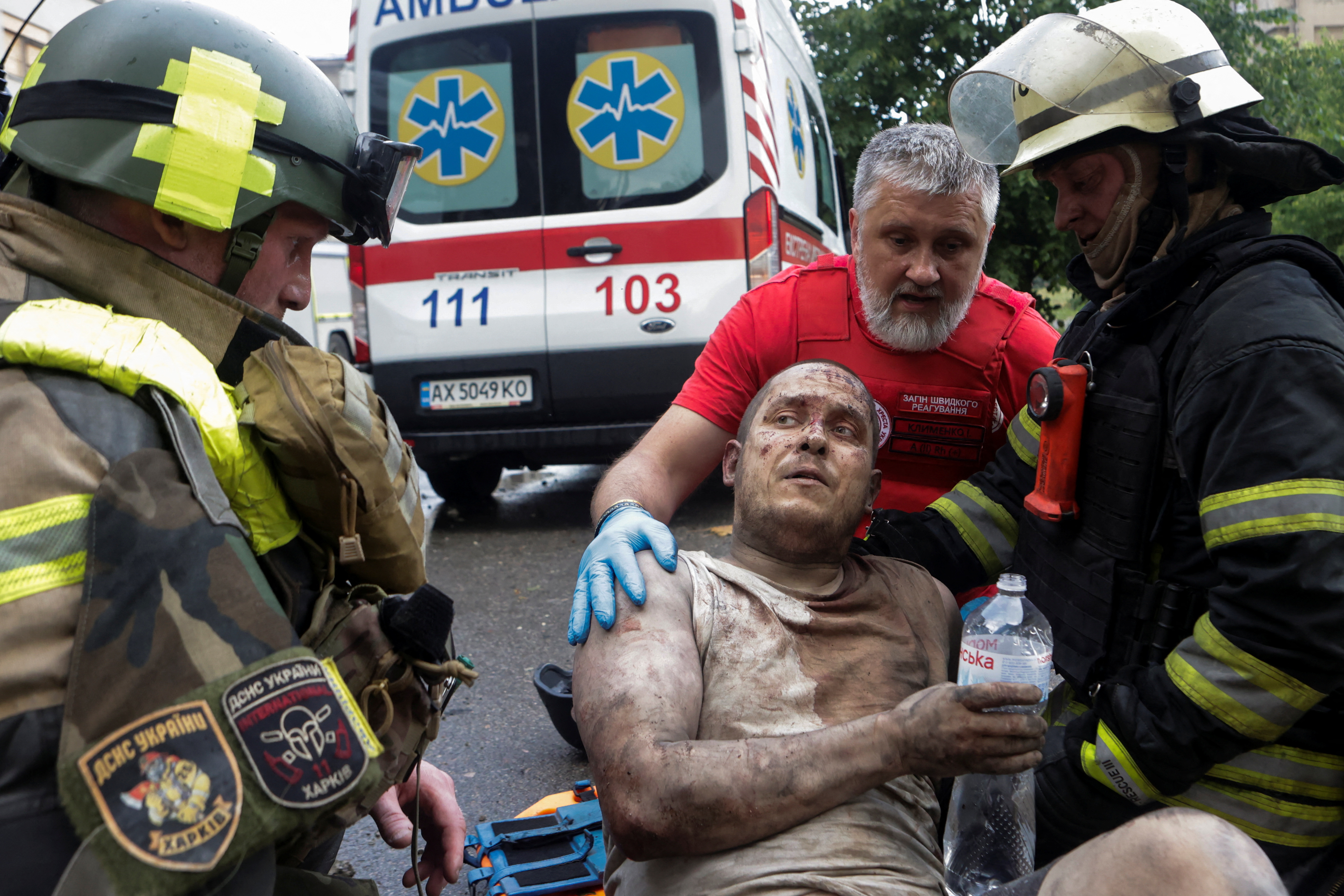 Rescuers and a paramedic speak with an injured resident after he was released from debris of a building hit by a Russian drone strike, amid Russia's attack on Ukraine, in Kharkiv, Ukraine June 7, 2025. REUTERS/Sofiia Gatilova