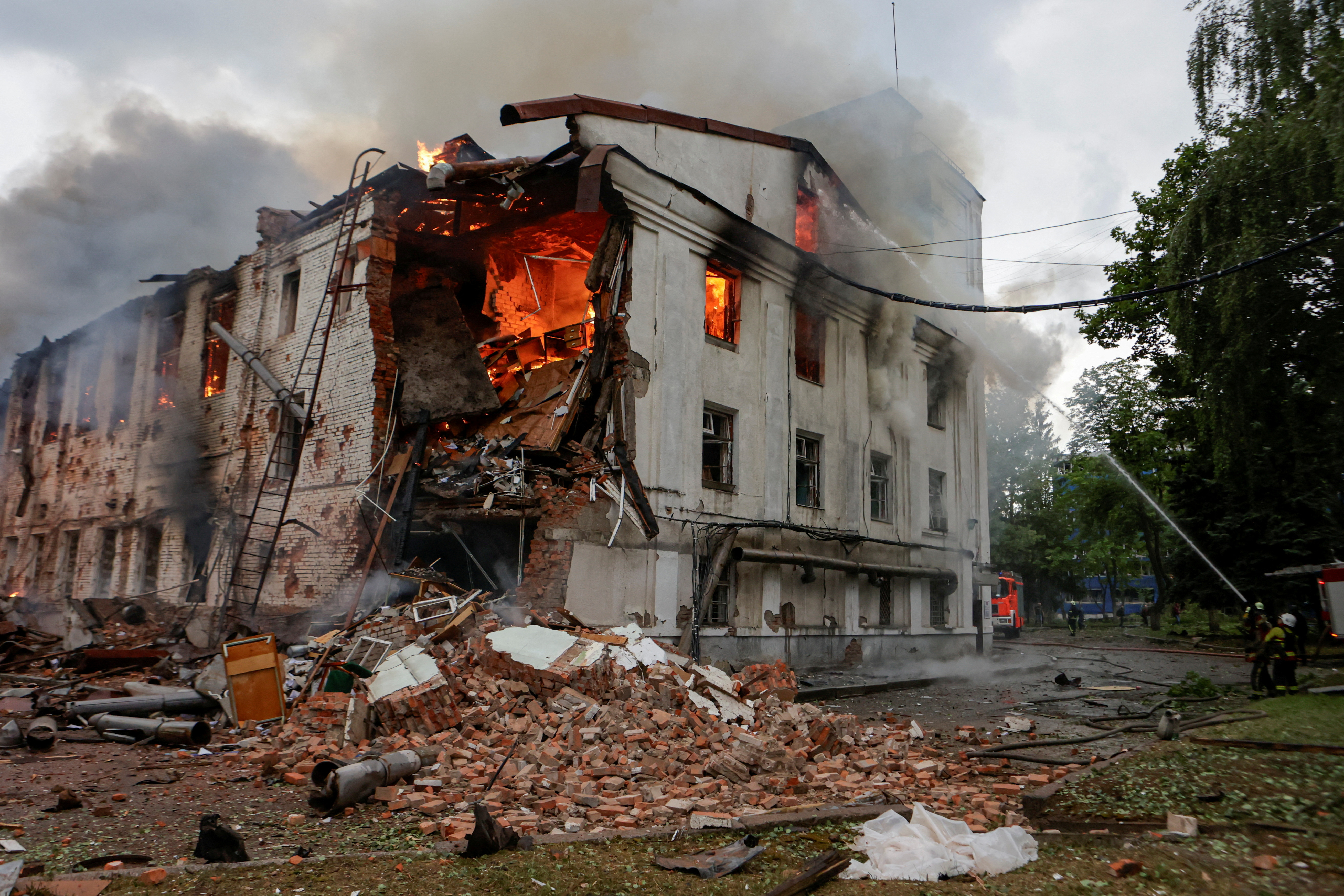 Firefighters work at the site of a building hit by a Russian drone attack in Kharkiv, Ukraine
